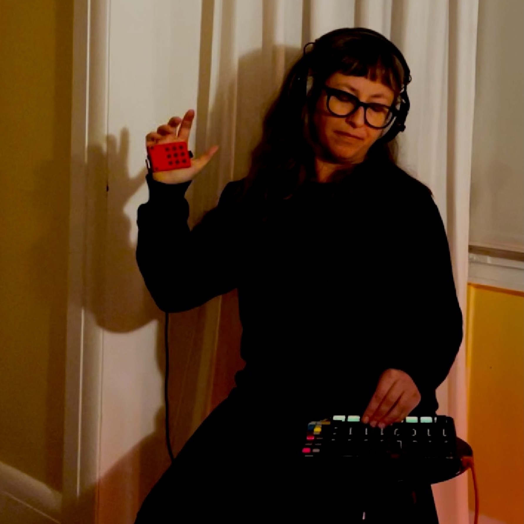 Jessie Newling - Temporal: a woman holding a dj controller in front of a window