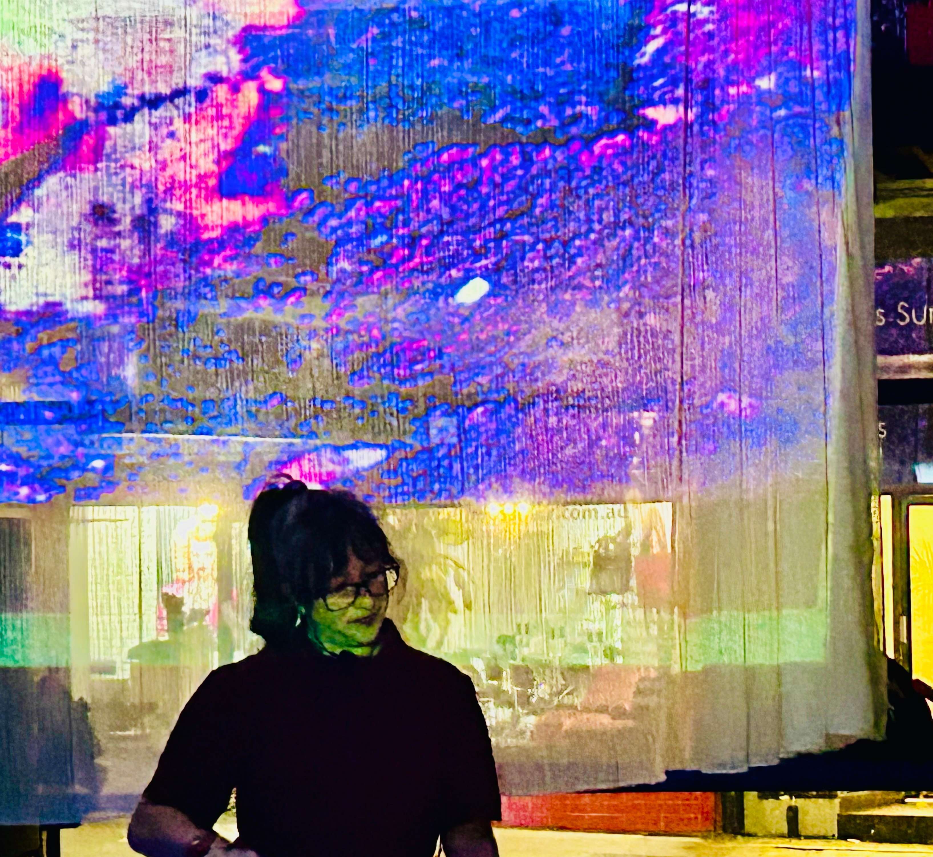 a woman standing in front of a large screen