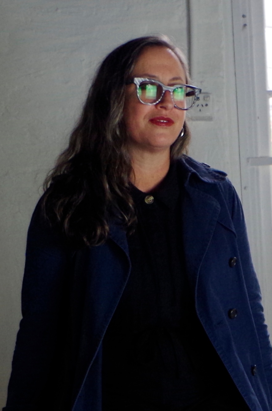 a woman wearing glasses and a trench coat