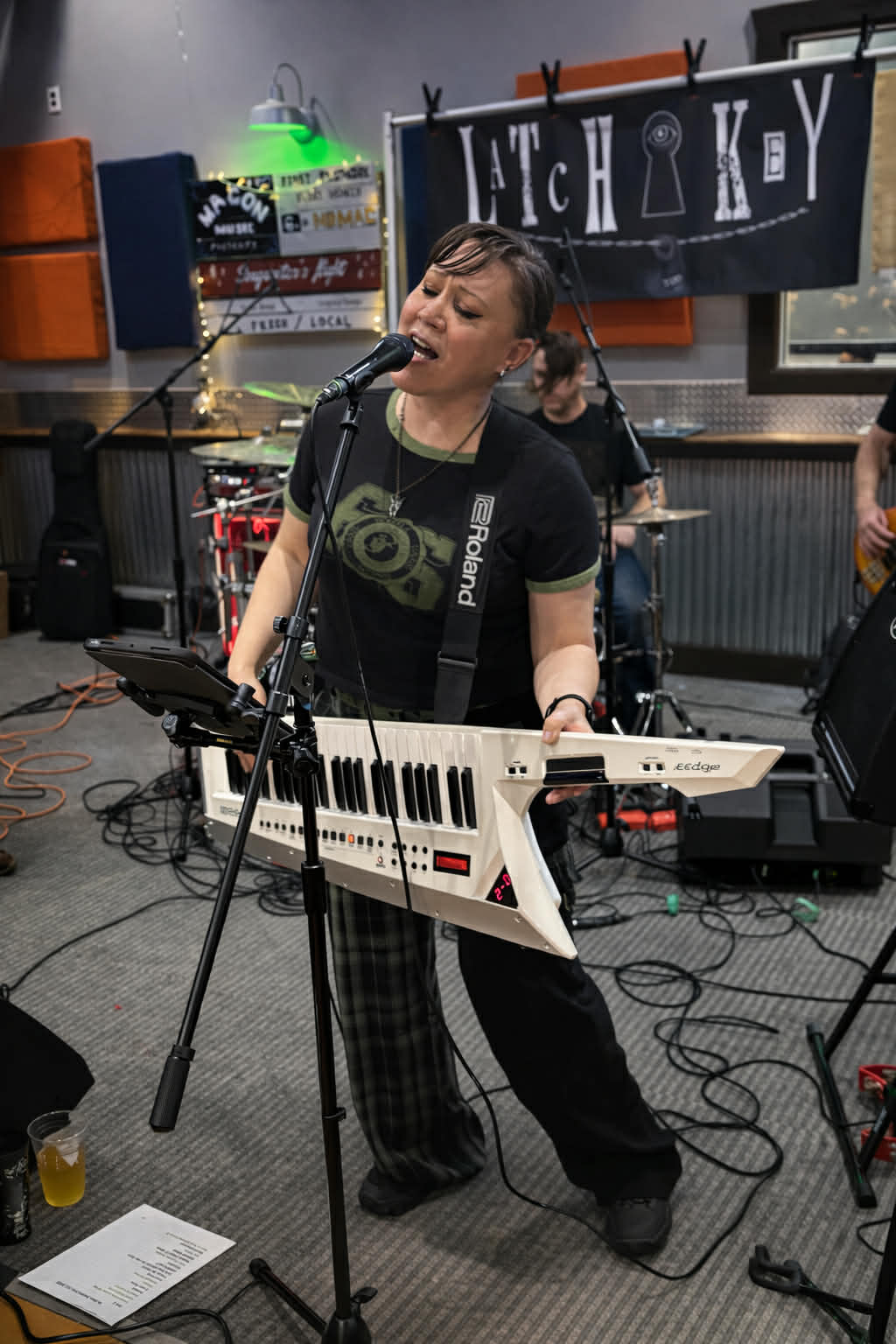 a woman playing a keyboard in a recording studio