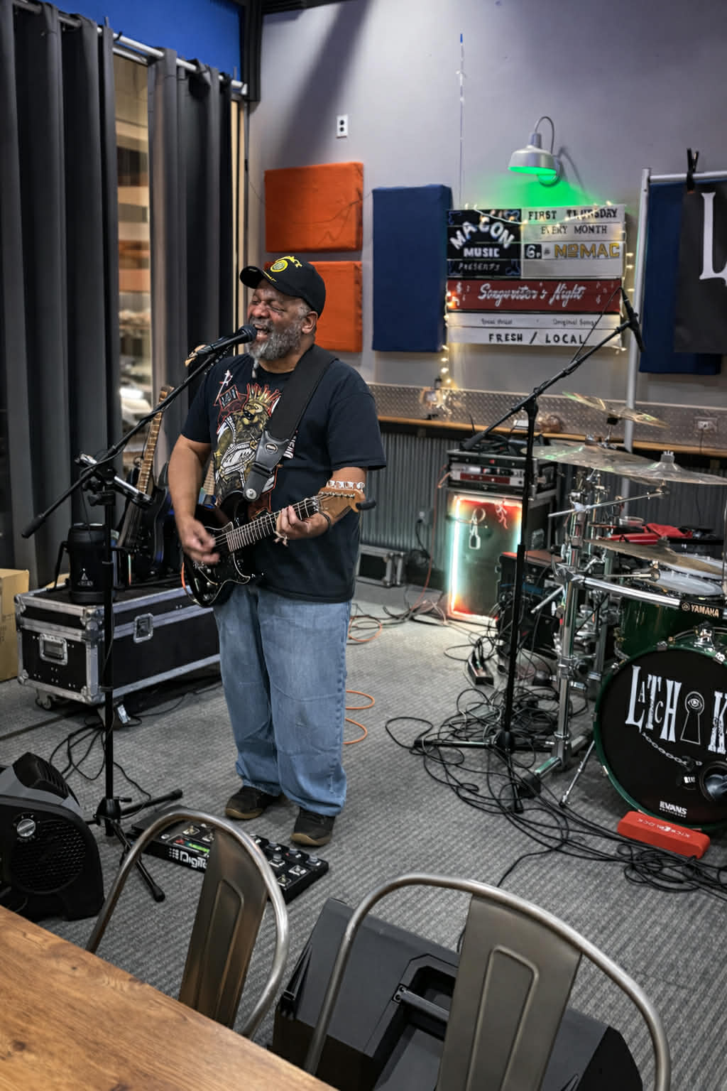 a man playing guitar in a recording studio