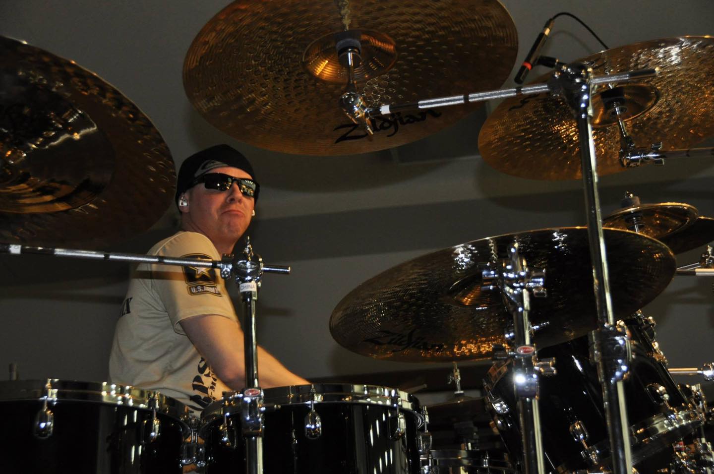 a man in sunglasses playing drums in a room