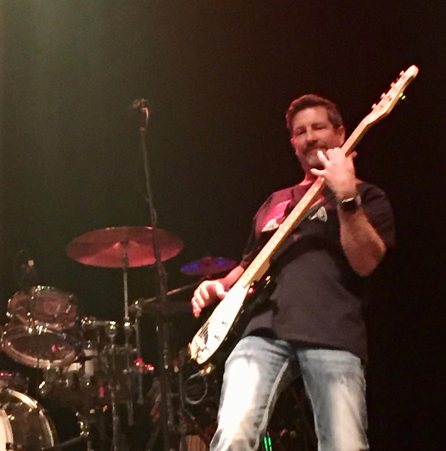 a man standing on stage with a guitar