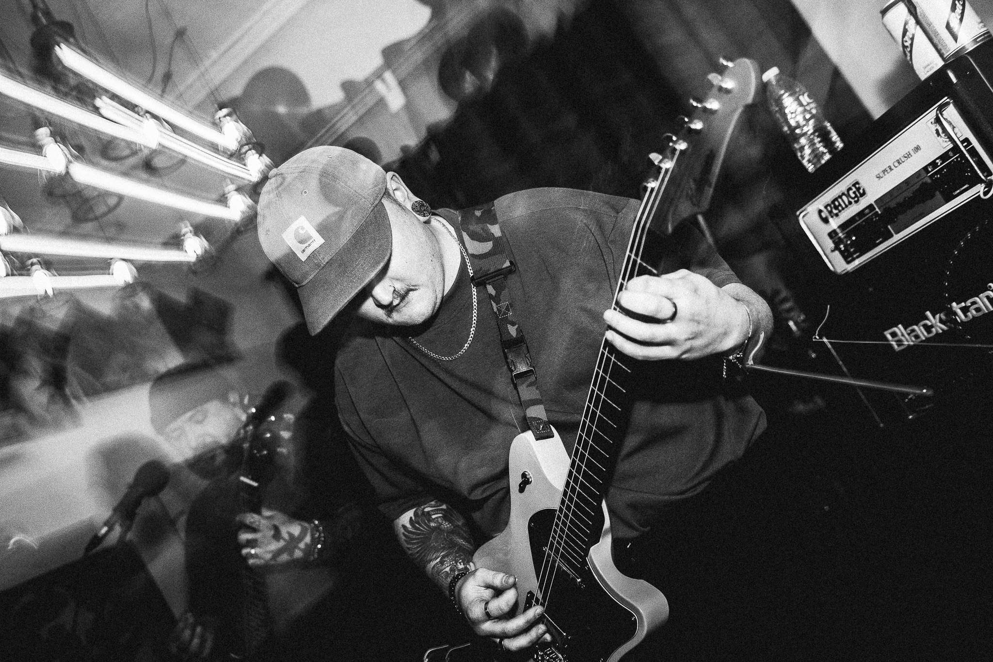 a black and white photo of a man playing a guitar