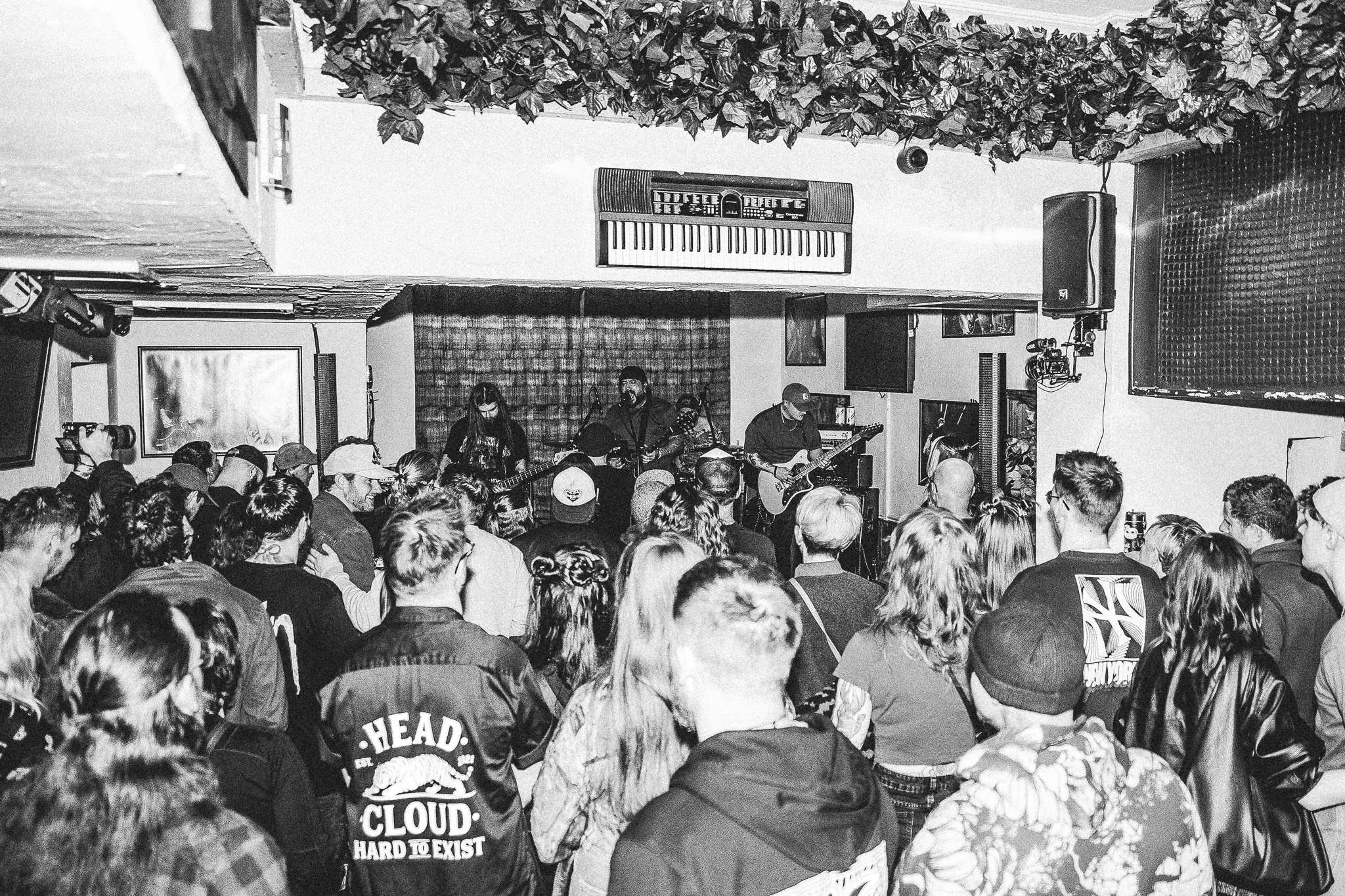 a black and white photo of a crowd in a bar