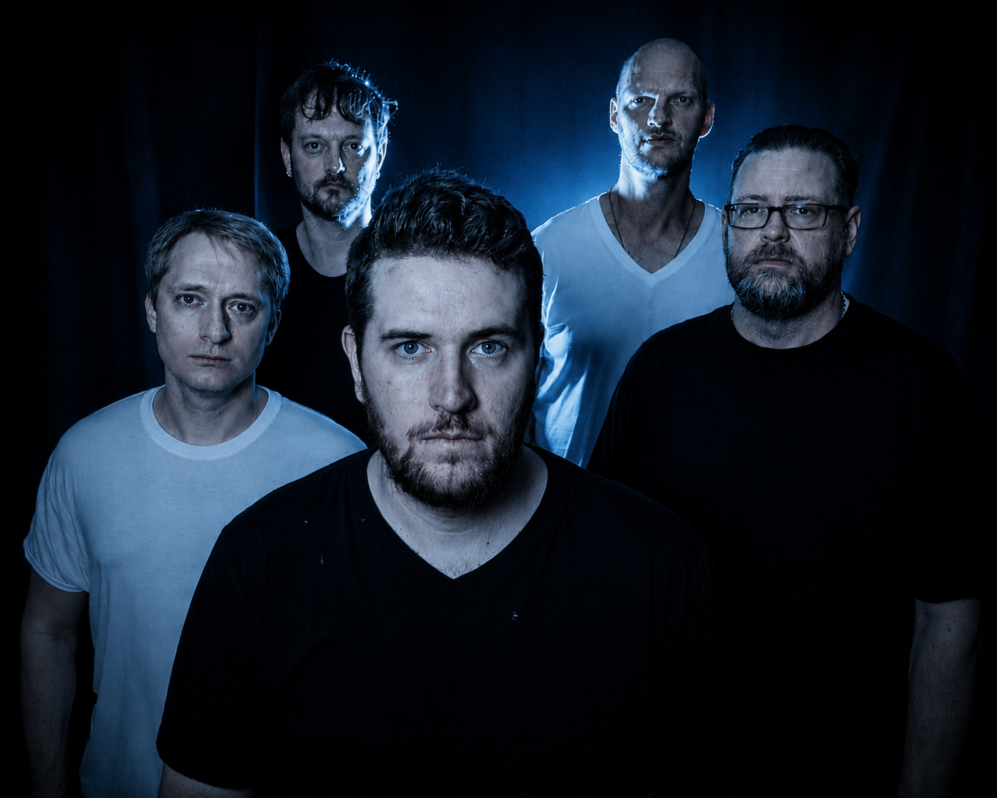 a group of men standing in front of a blue background