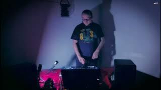 a man is playing a dj set in a dark room