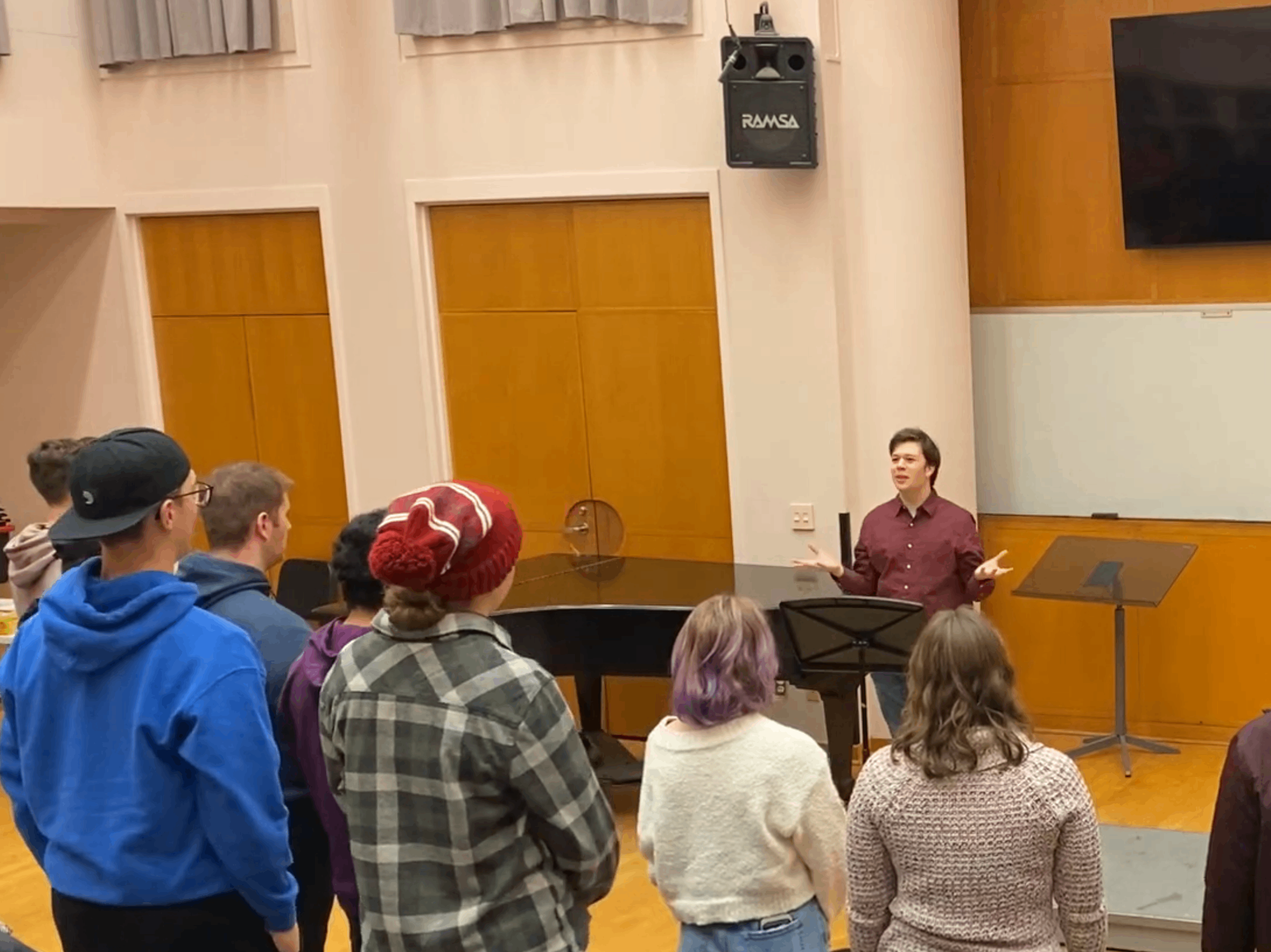 a group of people standing in front of a piano