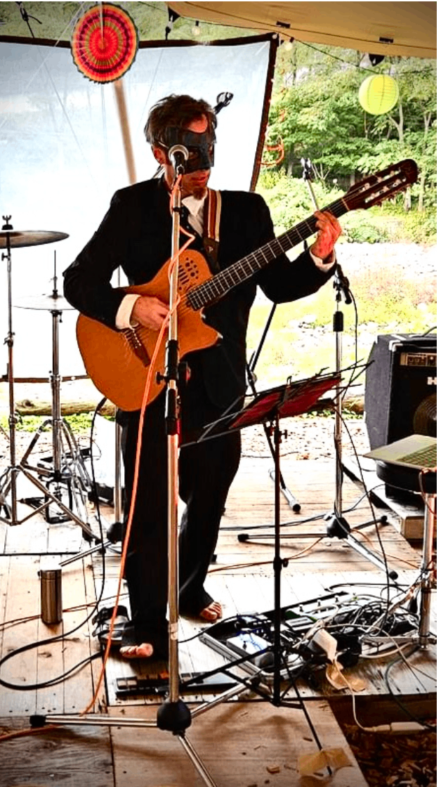 a man in a suit playing an acoustic guitar