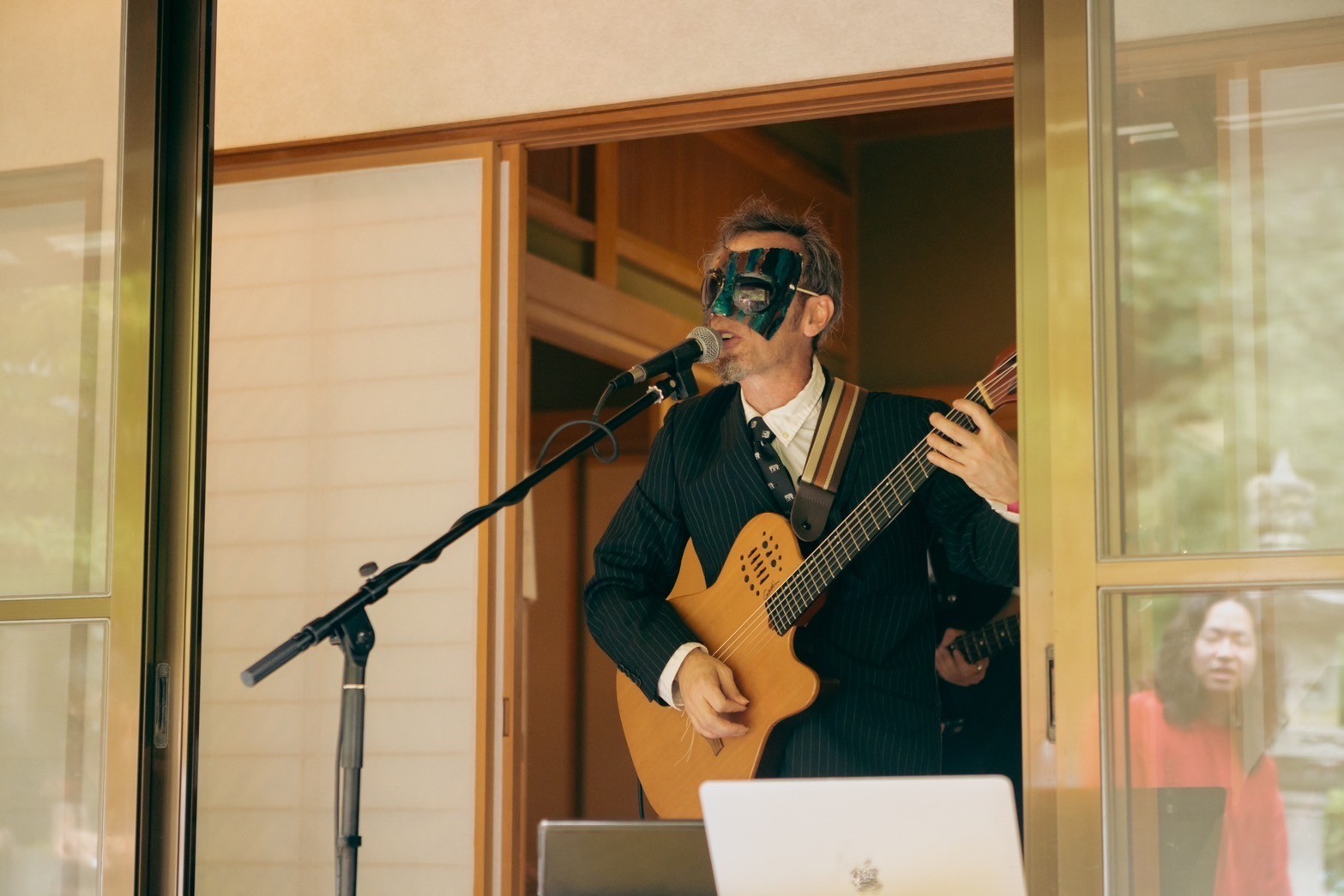 a man in a suit playing an acoustic guitar