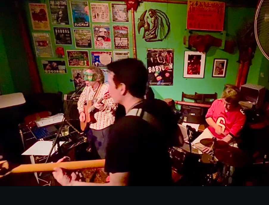 a group of people playing a musical instrument in a green room