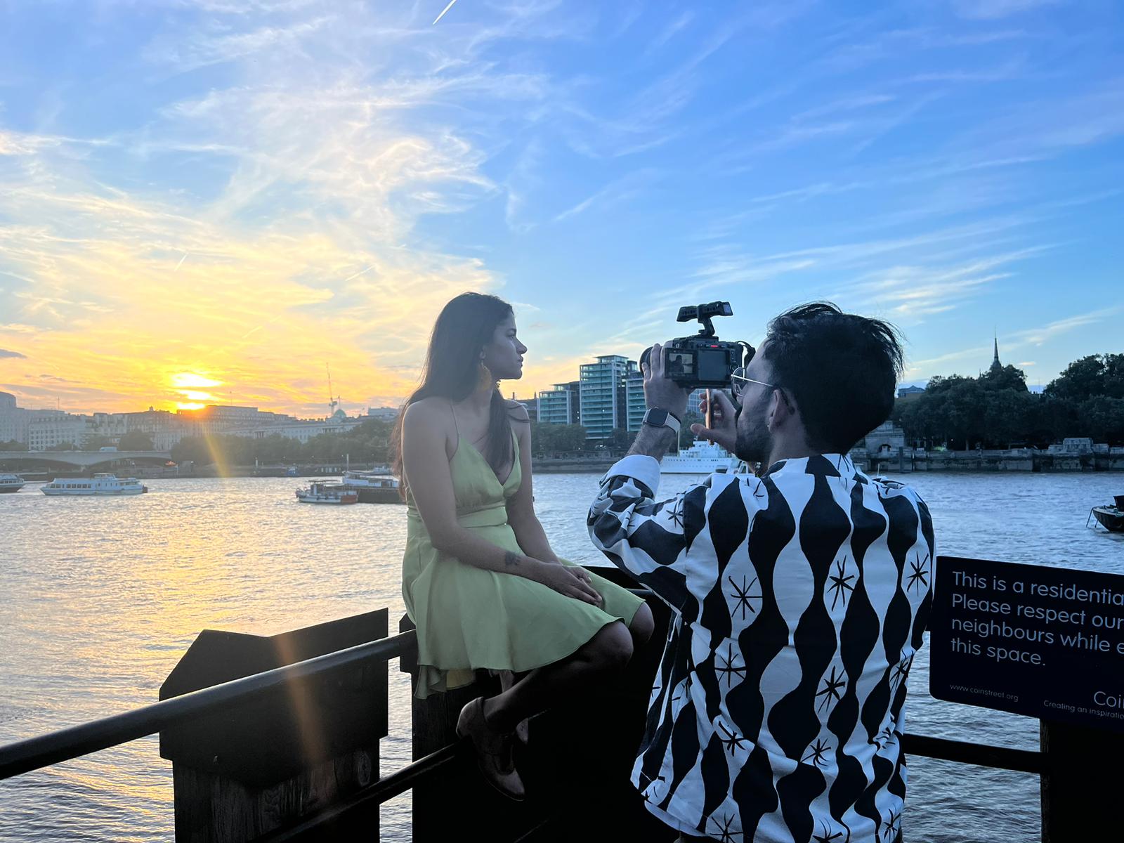 a man is taking a picture of a woman at sunset