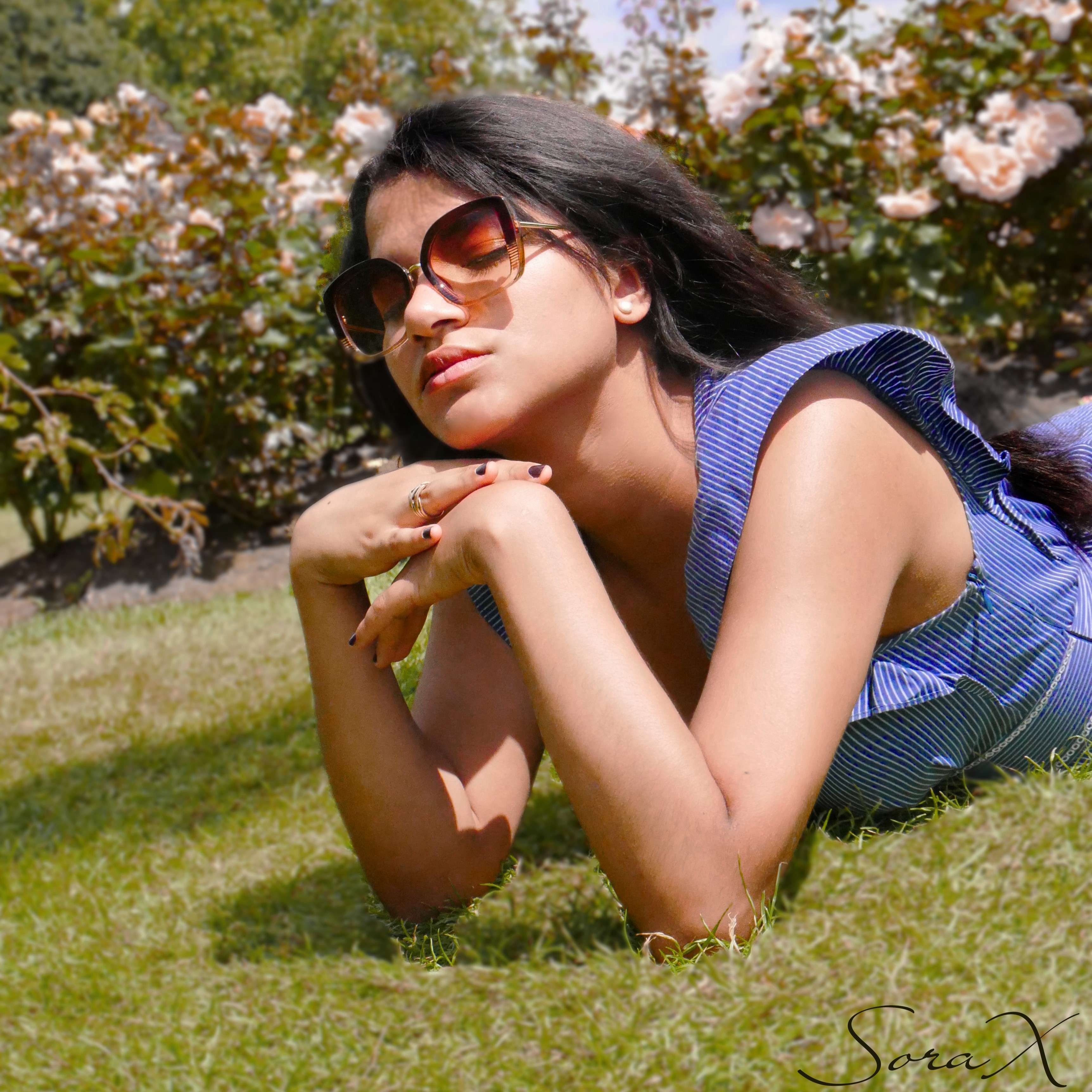 a woman in a blue dress laying on the grass