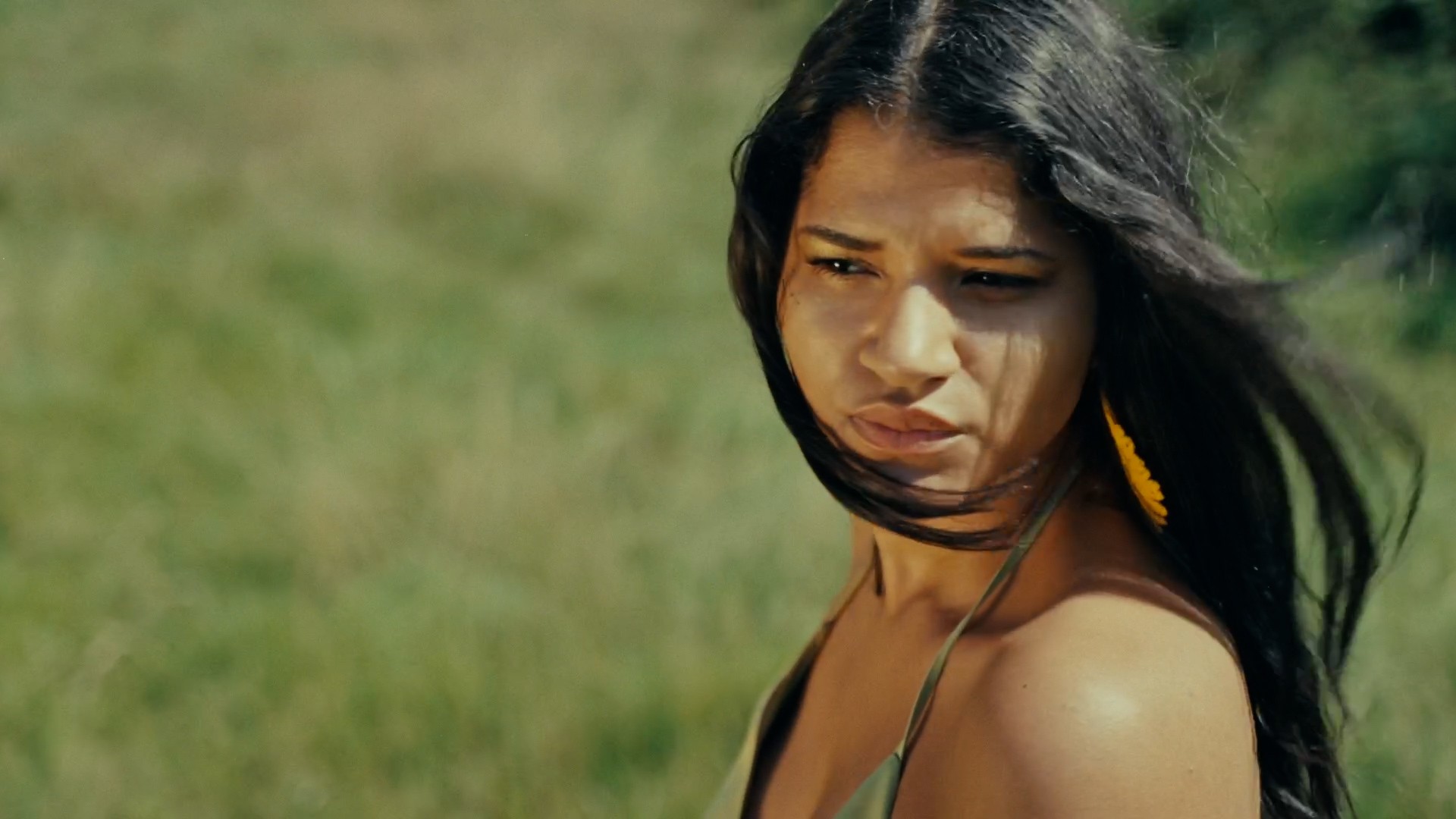 a woman with long hair standing in a field