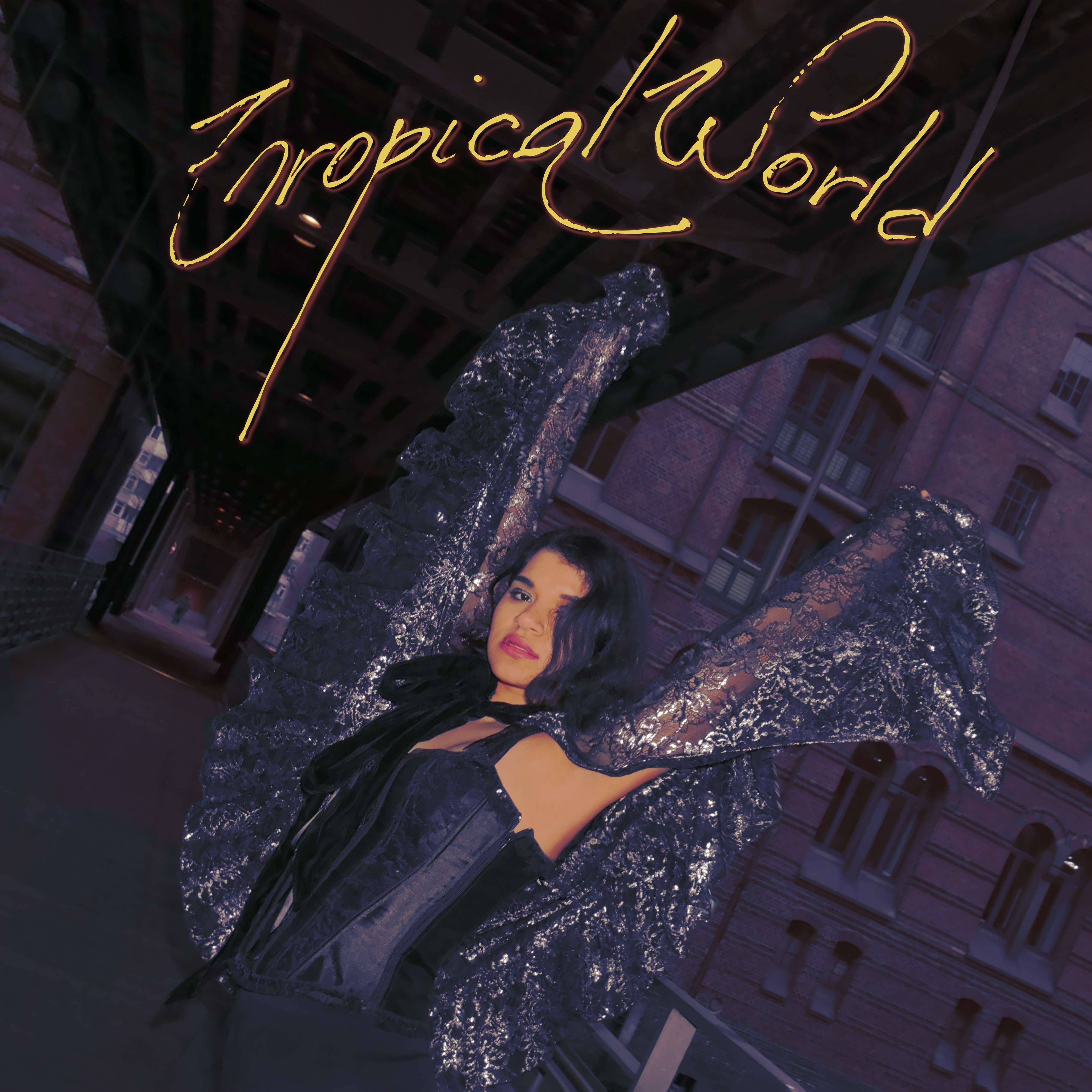 a woman in a black dress is posing under a bridge