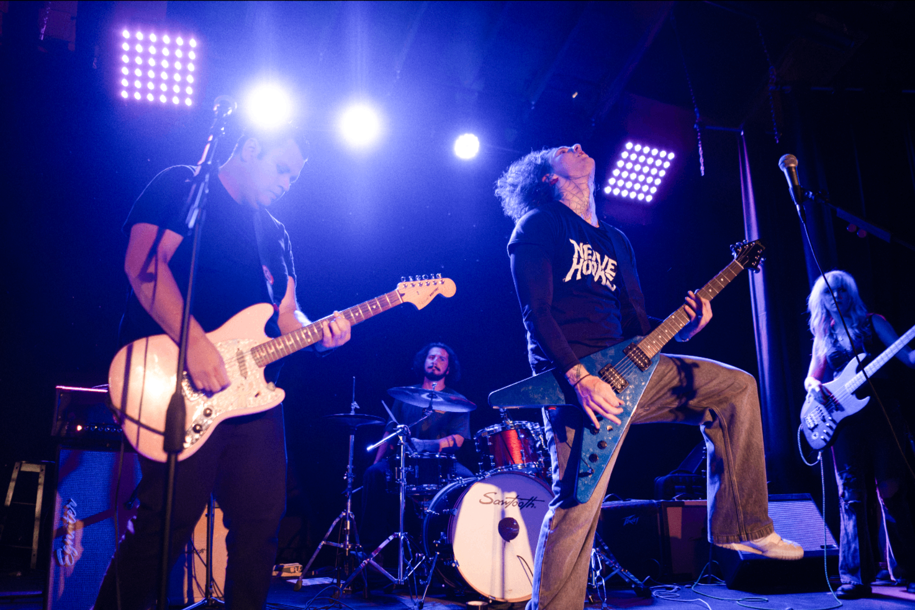 a group of people playing guitar on stage