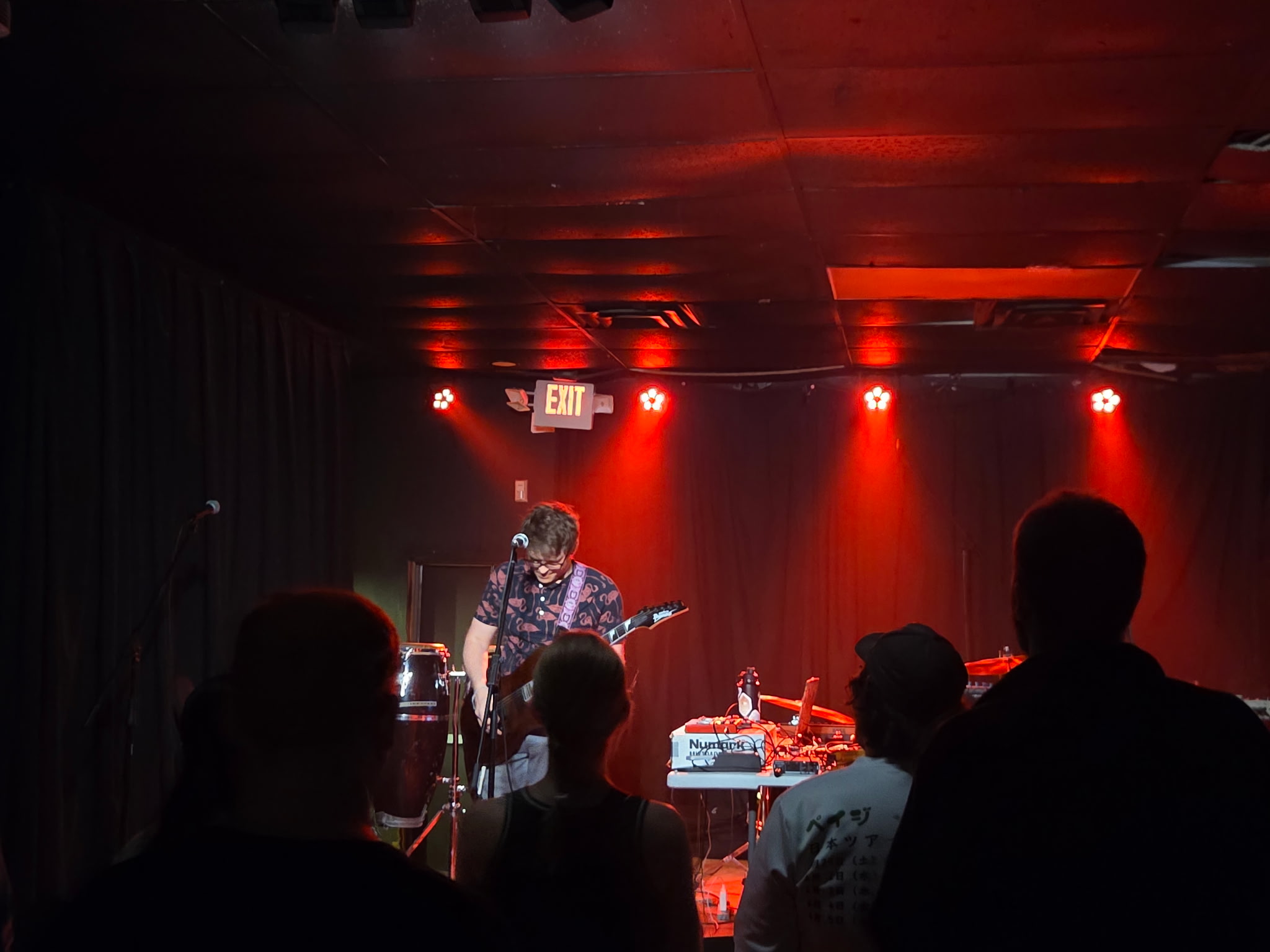 a group of people watching a band perform in a dark room