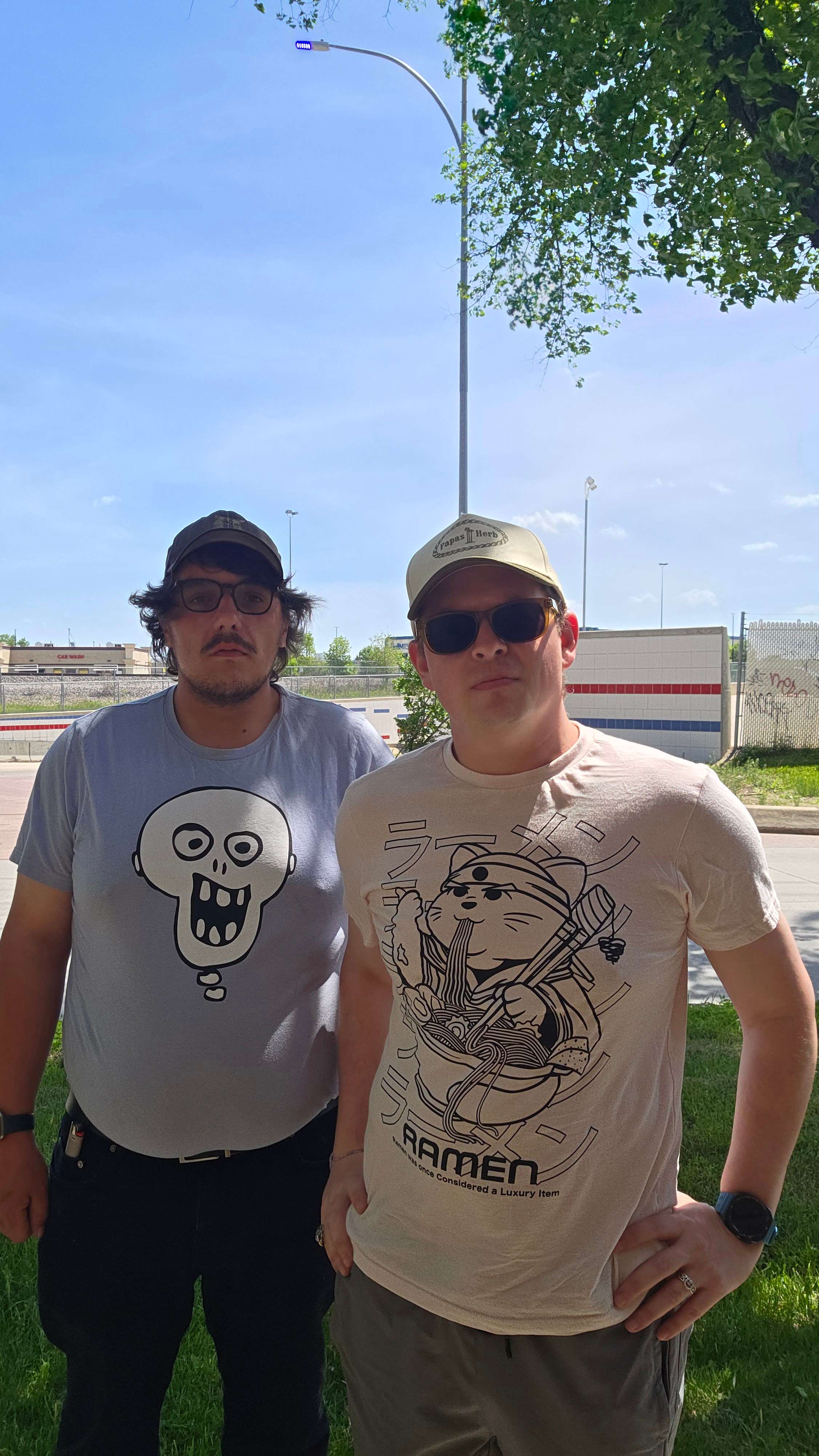 two men standing next to each other in a park