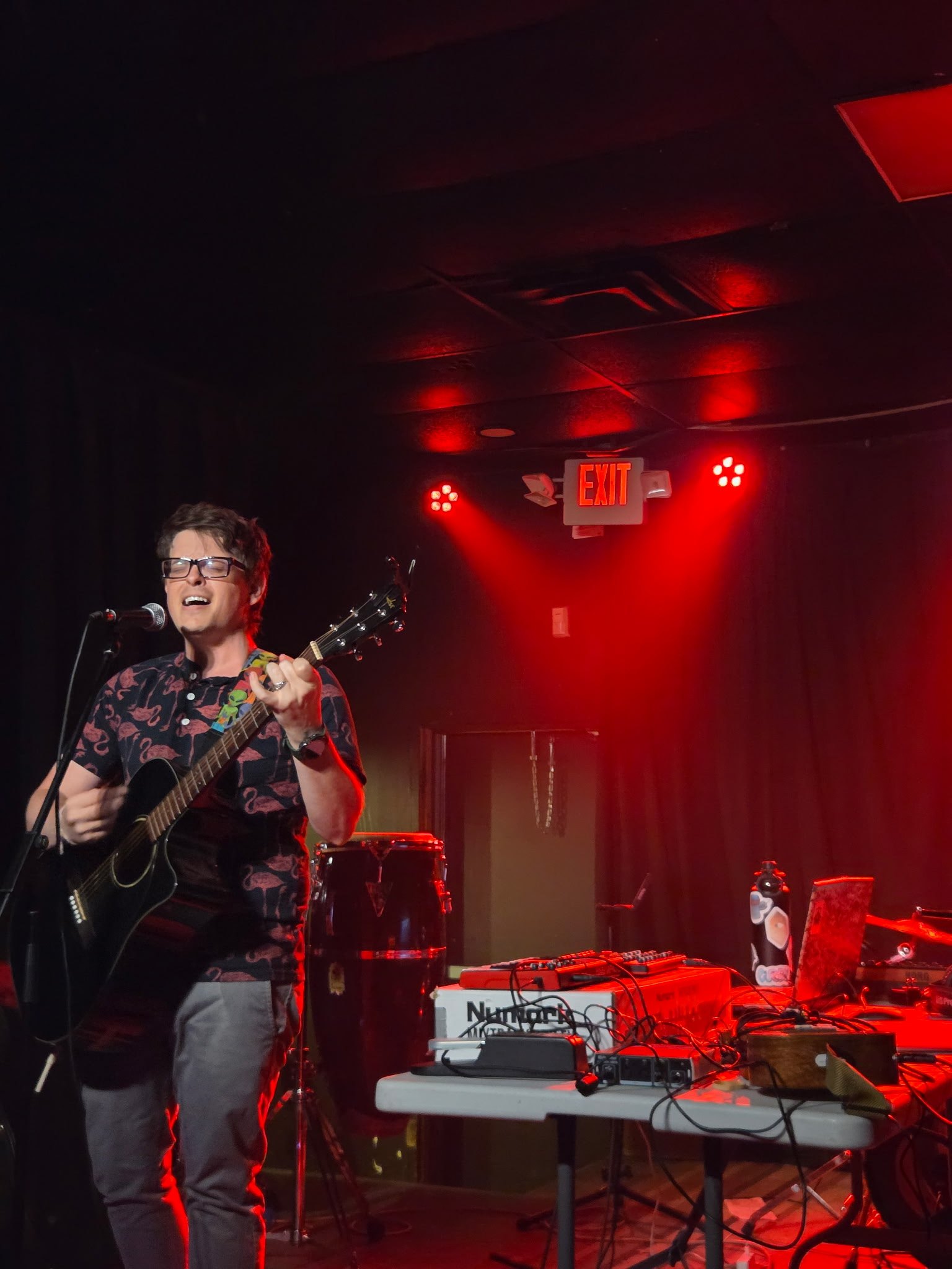 a man playing an acoustic guitar on stage