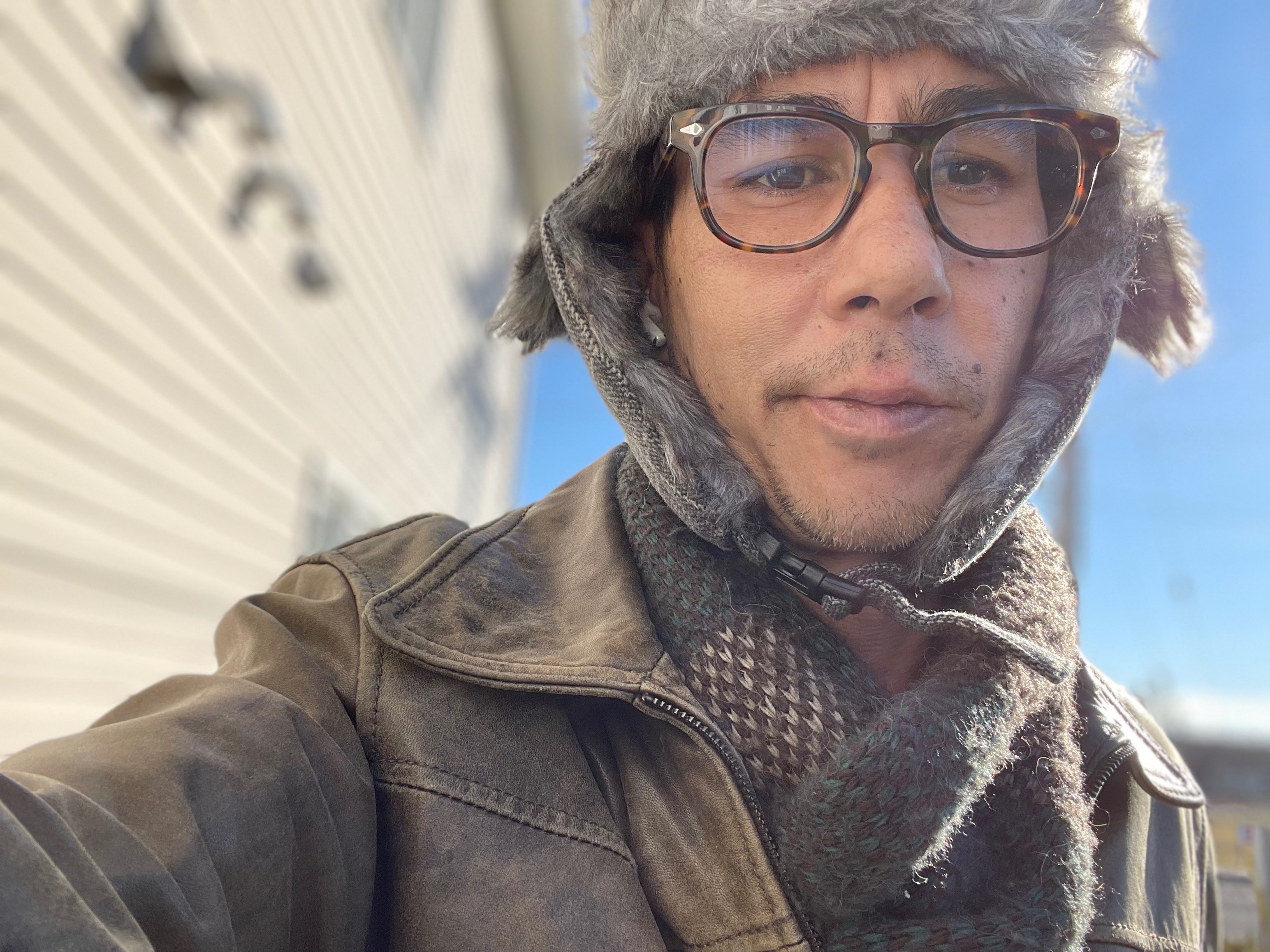 a man wearing glasses and a furry hat