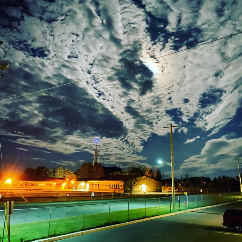 a full moon in the sky over a train track