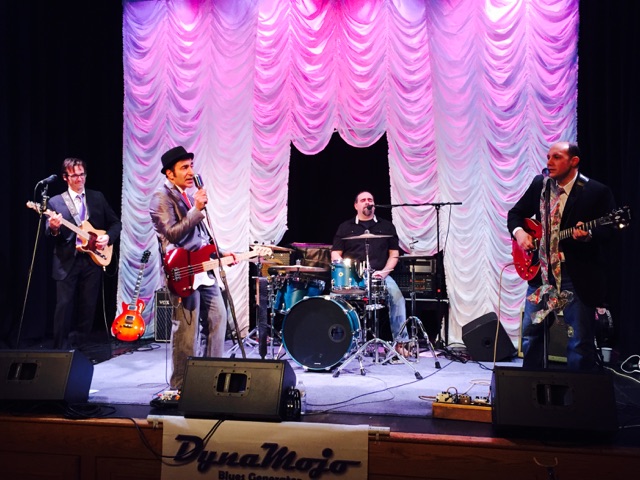 a group of people on stage with guitars and drums
