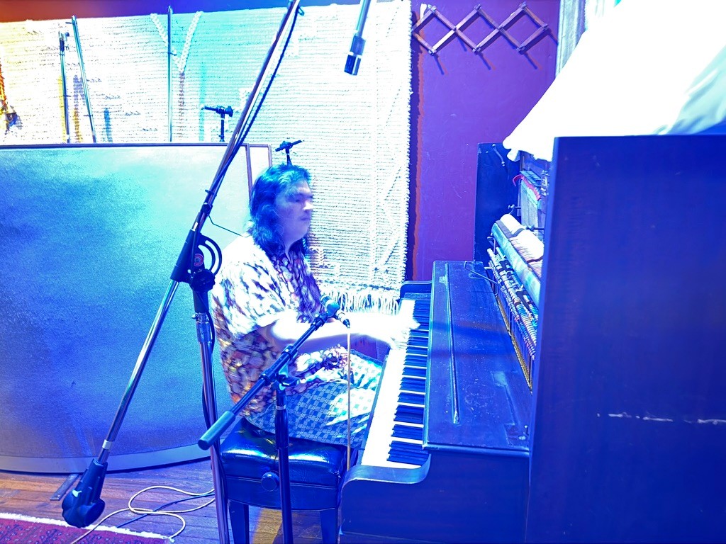 a man playing a piano in a recording studio