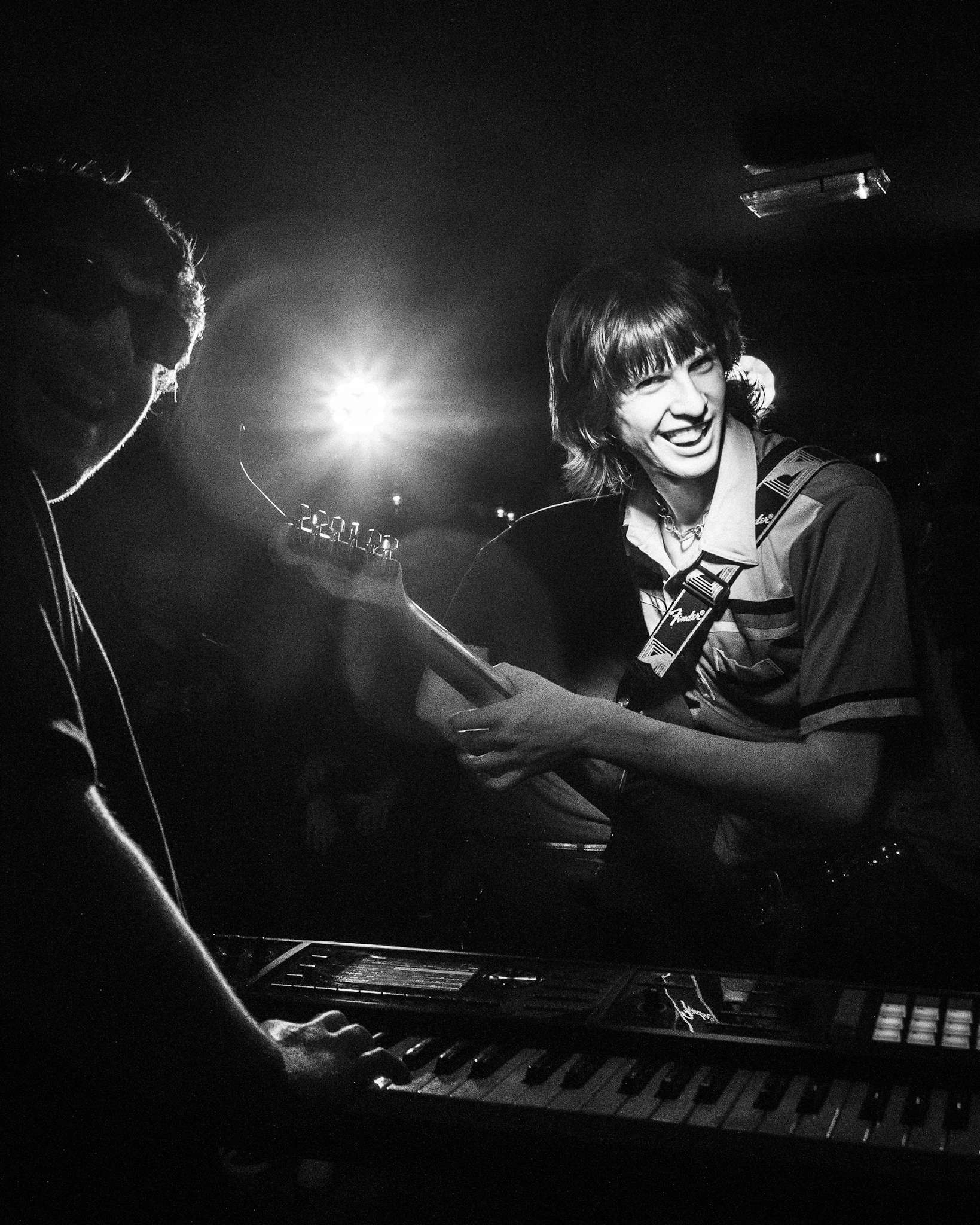 two men playing keyboards in a dark room