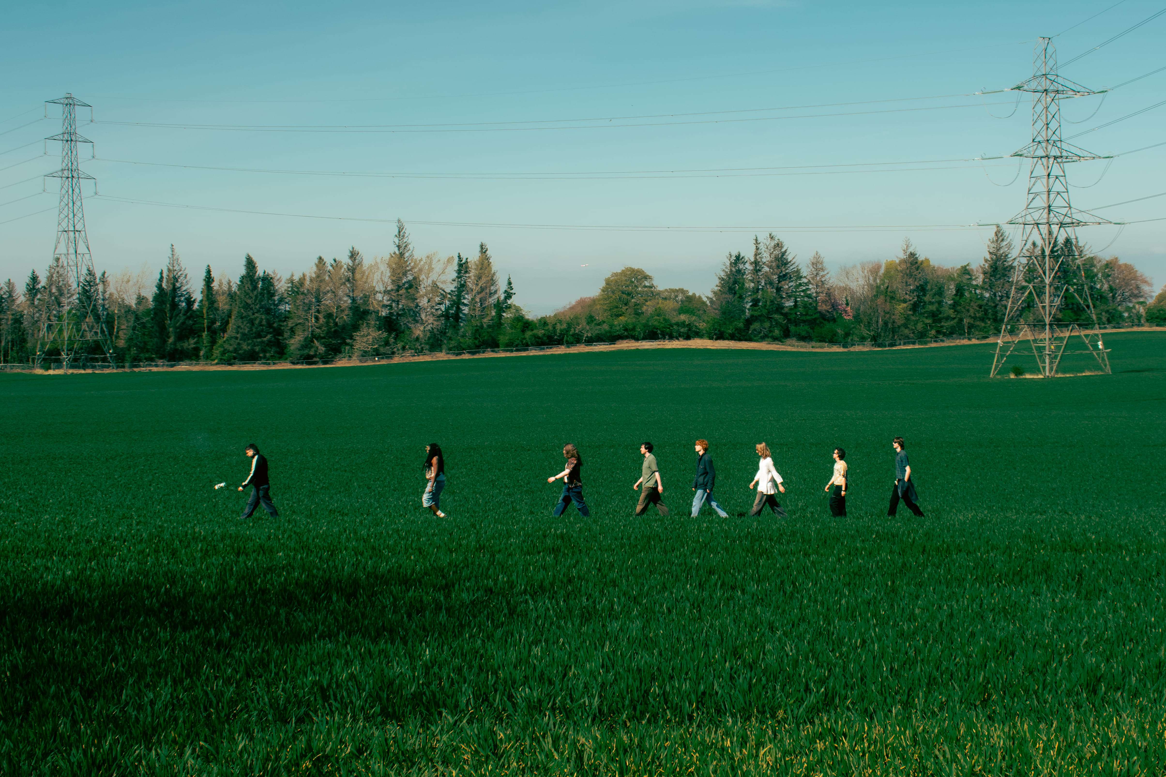 a group of people walking through a green field