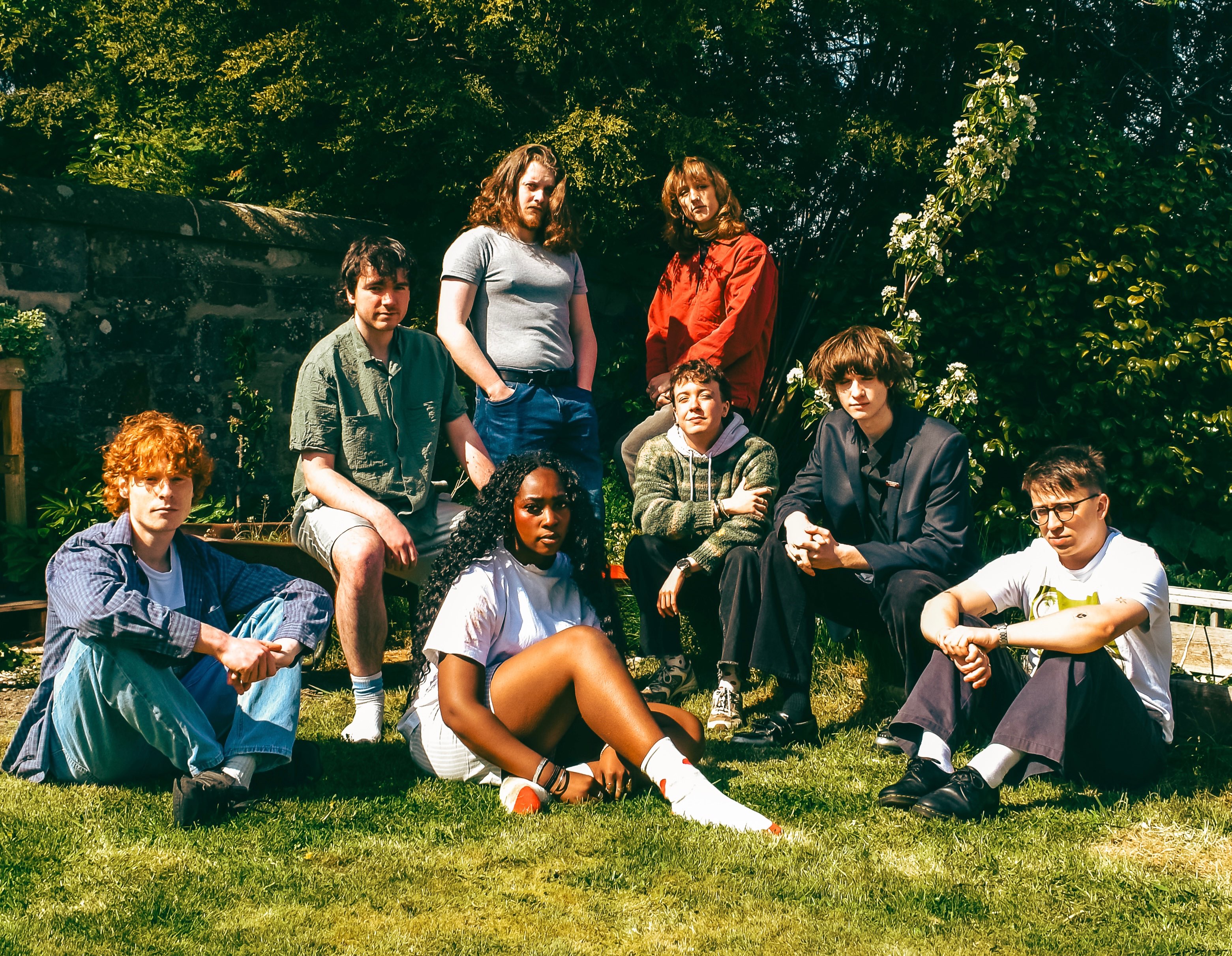 a group of people posing for a picture in a garden