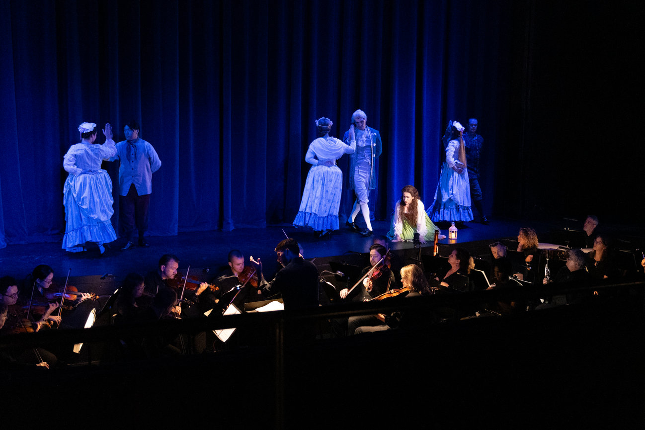 a group of people on stage with a conductor