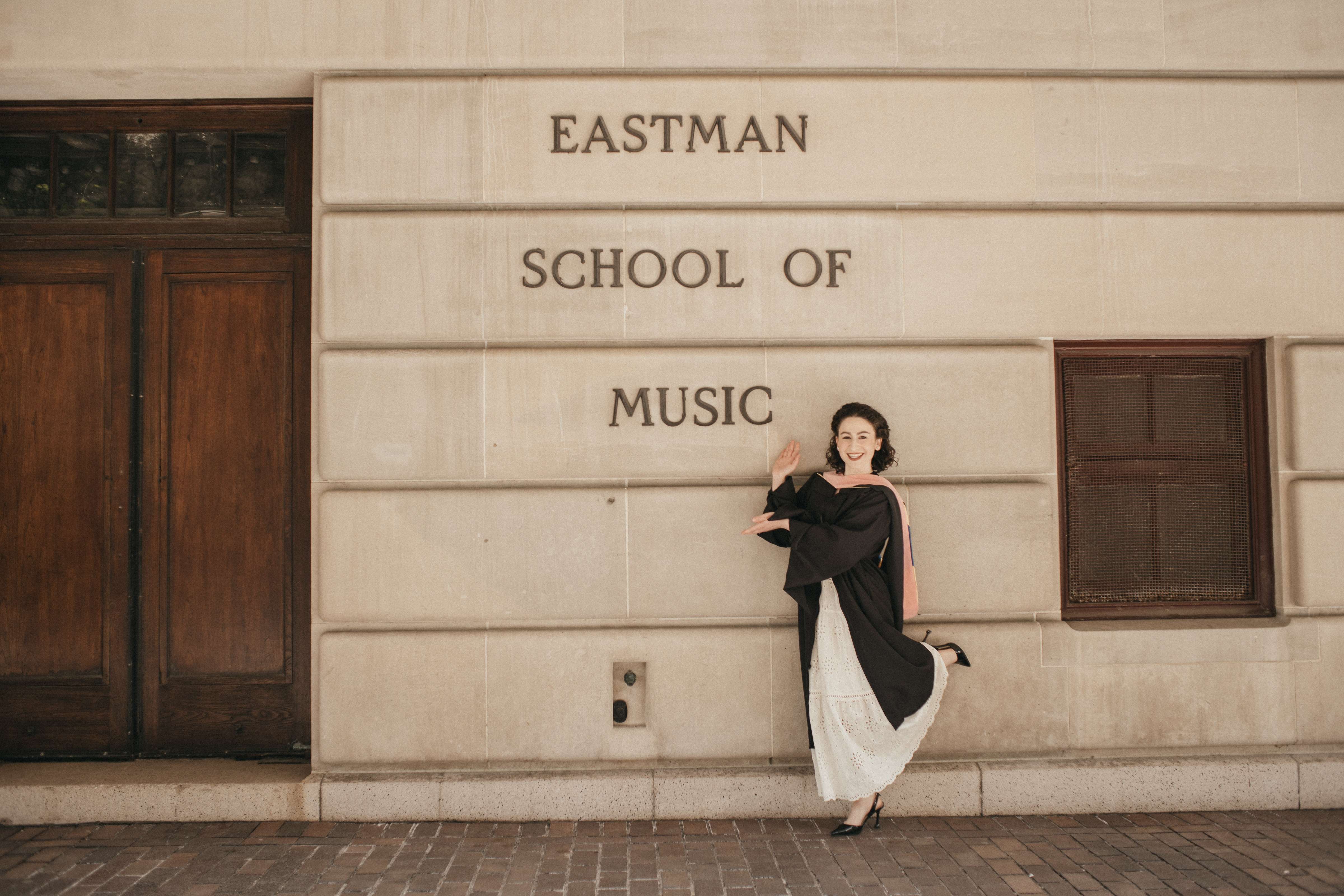 a woman standing in front of the eastman school of music