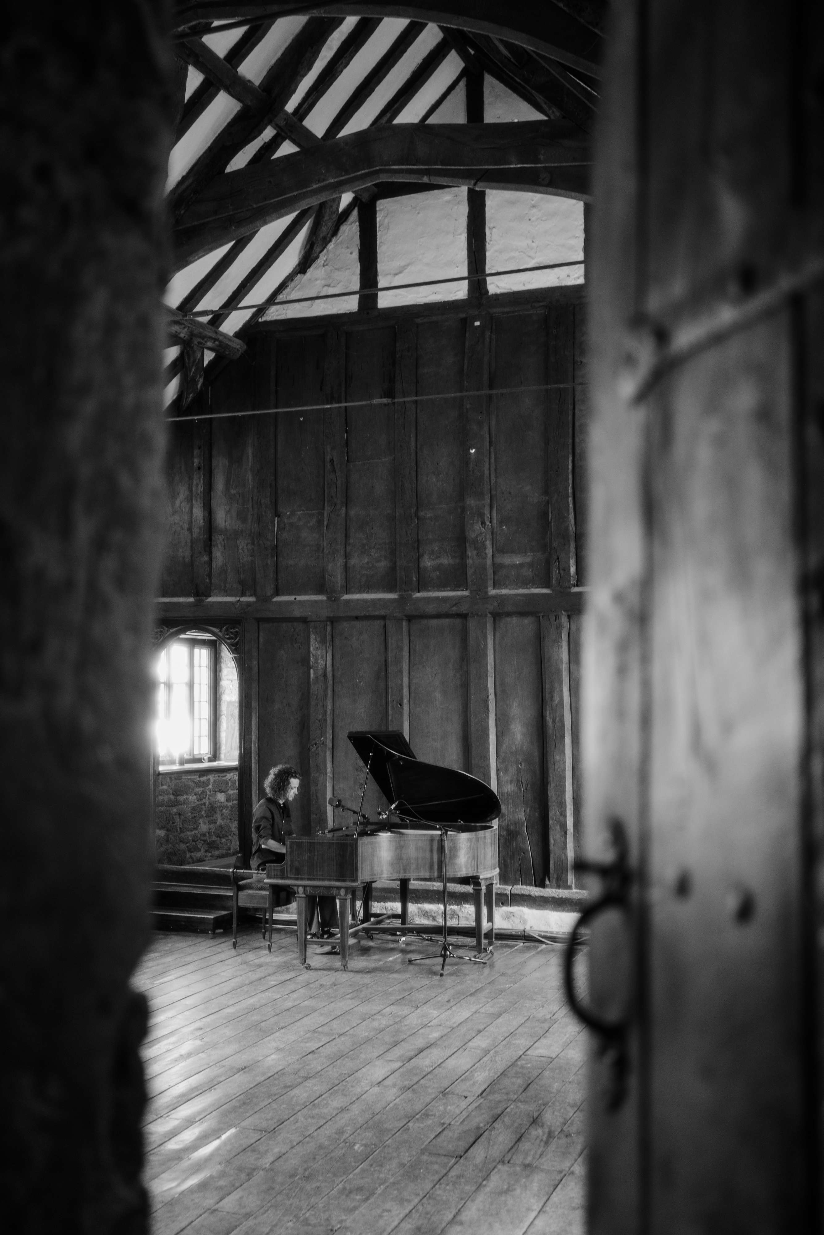 a black and white photo of a piano in an old building