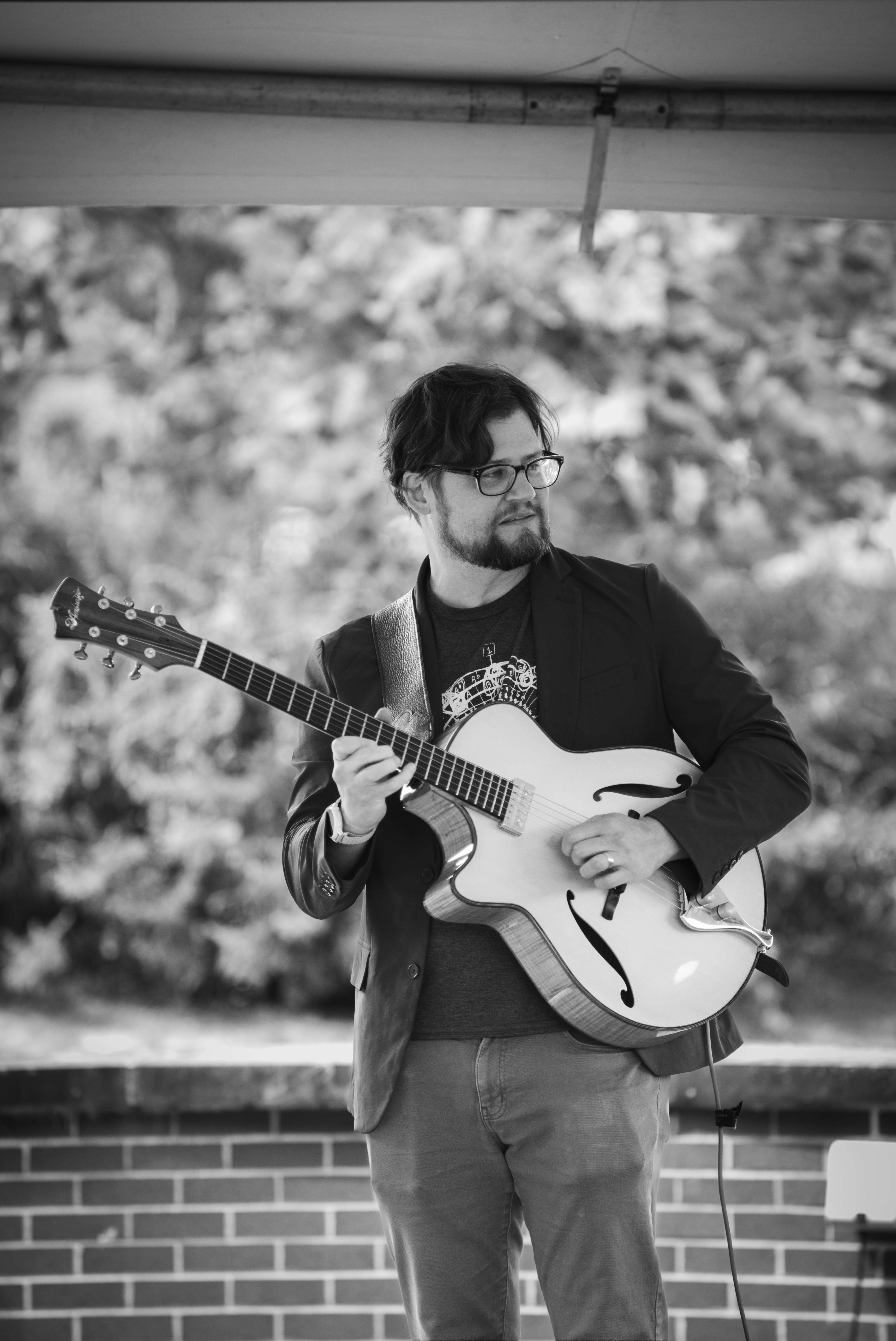 a man playing a guitar in a black and white photo