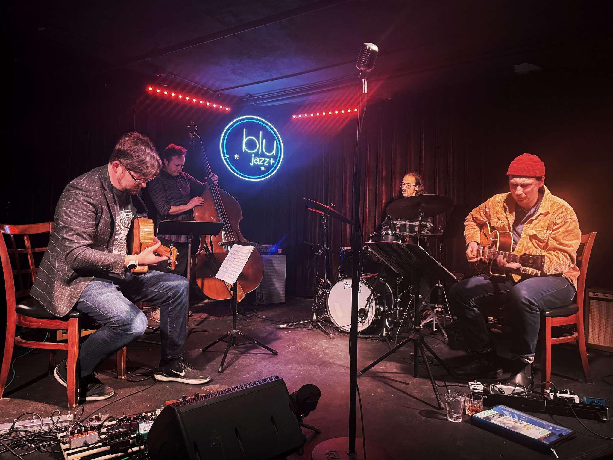 a group of musicians playing music in a dark room