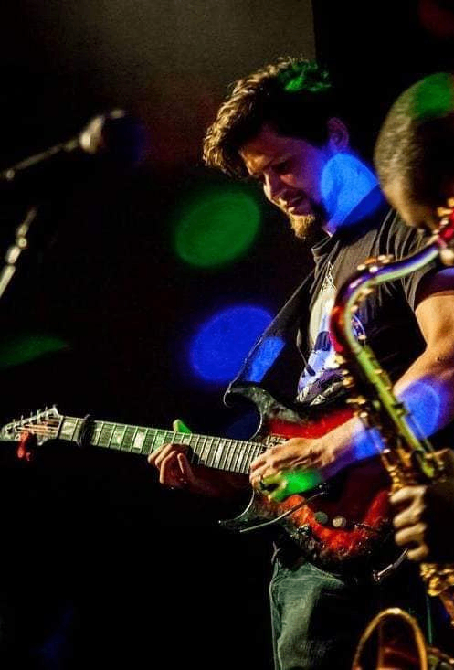 image may contain person, playing a musical instrument, on stage and night