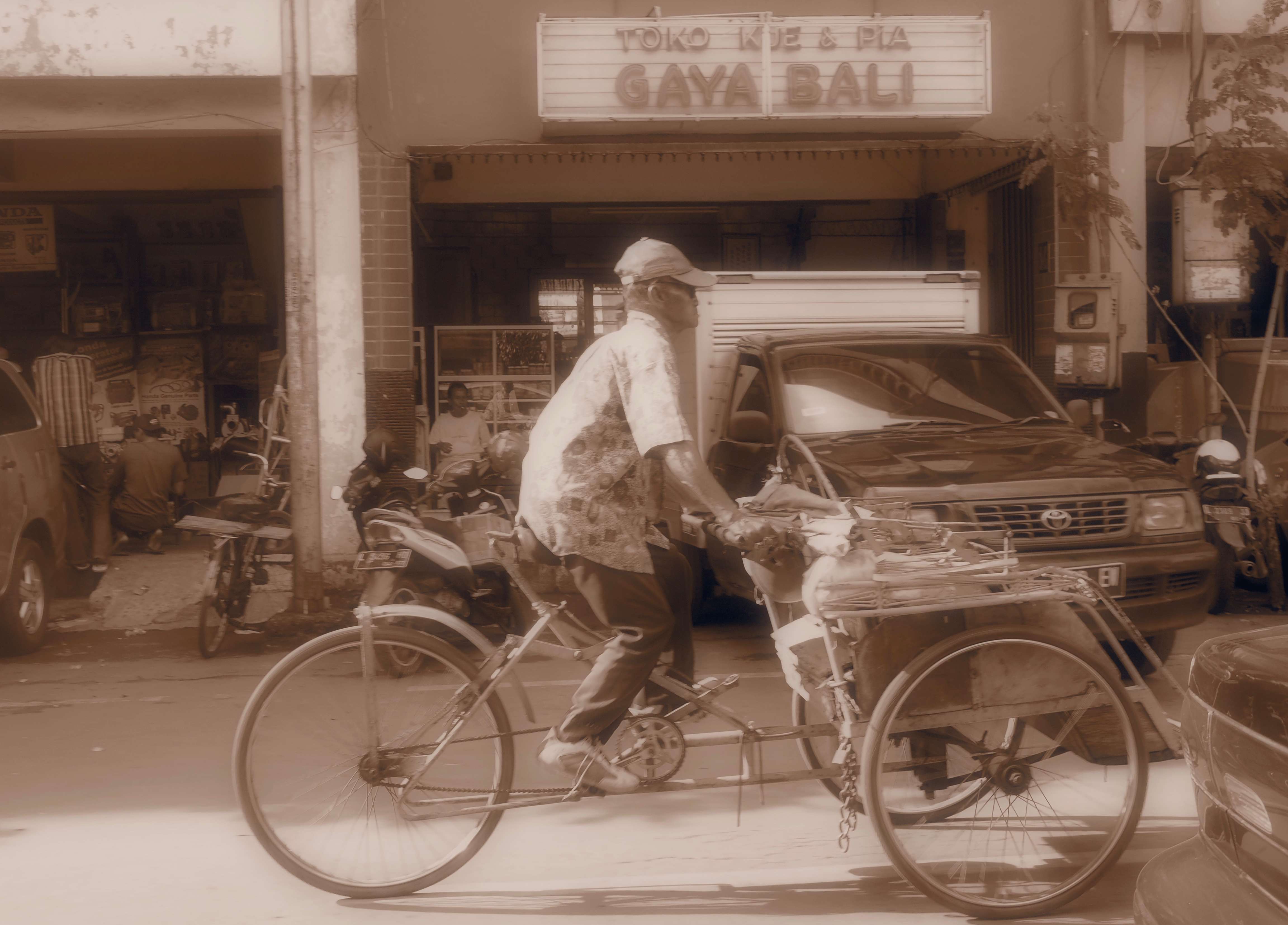 a man riding a bicycle with a cart