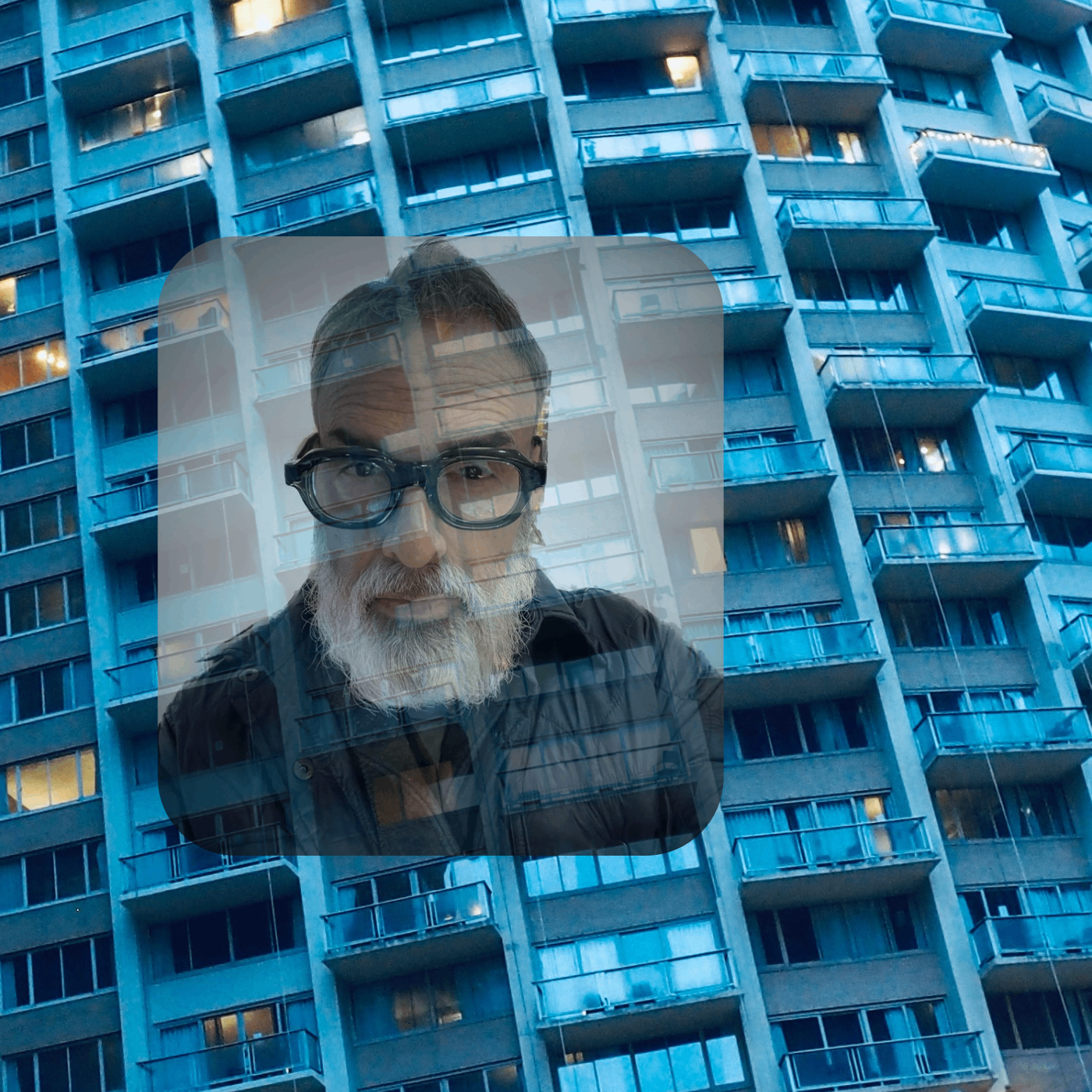 an image of a man with glasses in front of a building