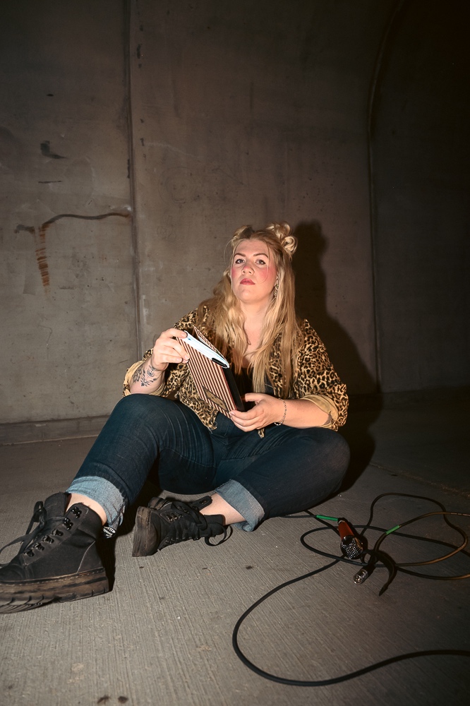 a woman sitting on the ground reading a book