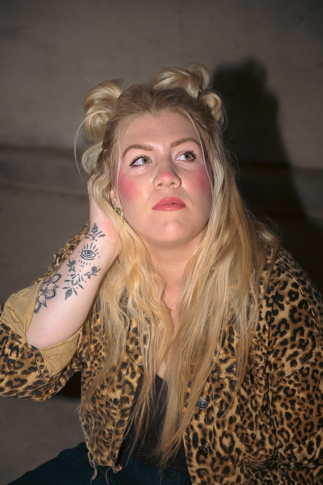 a woman wearing a leopard print jacket with tattoos