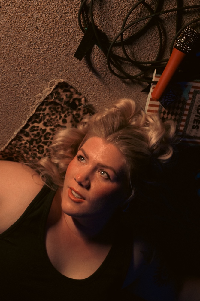 a woman laying on a bed with a microphone