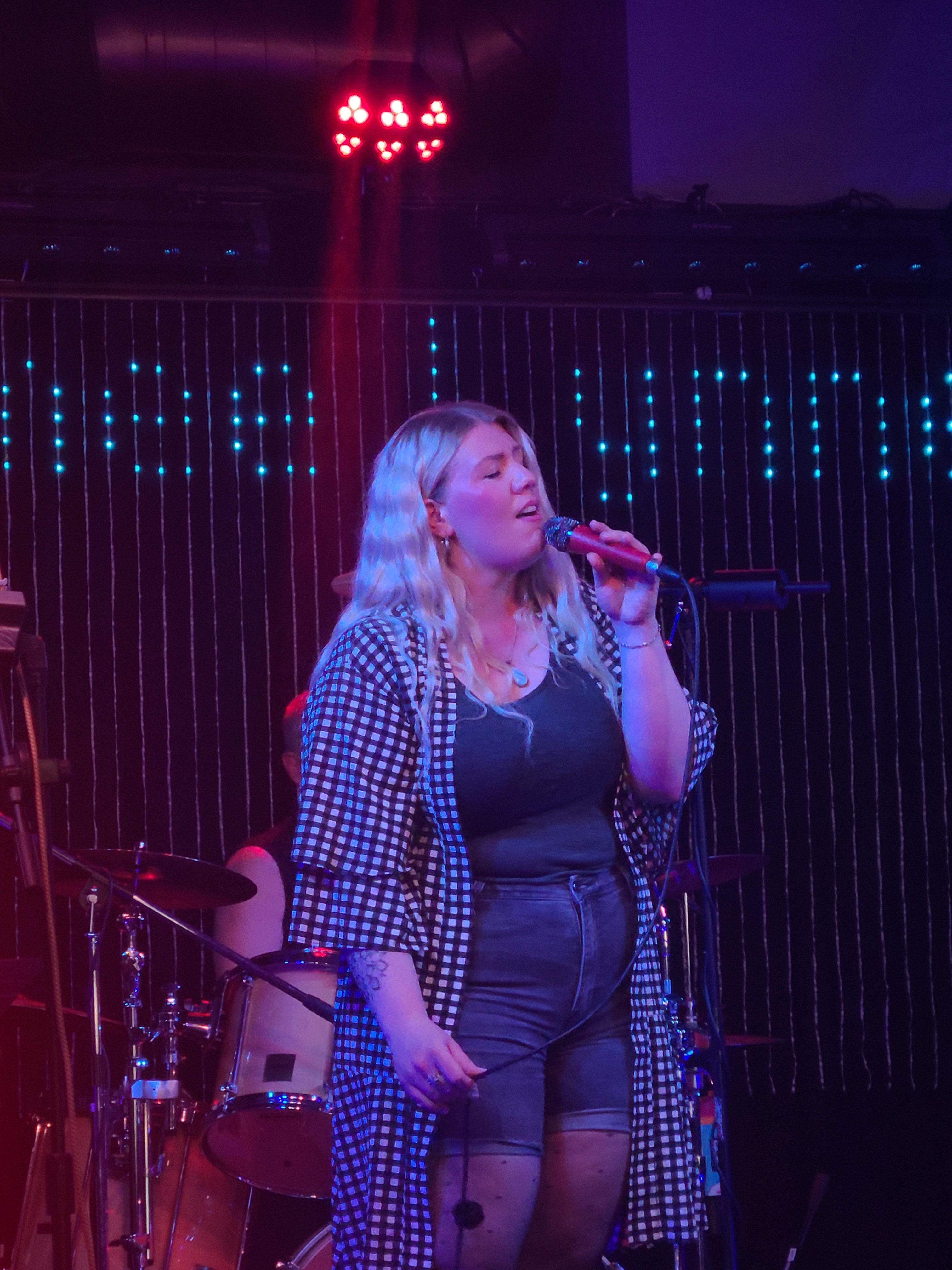 a woman singing into a microphone on stage