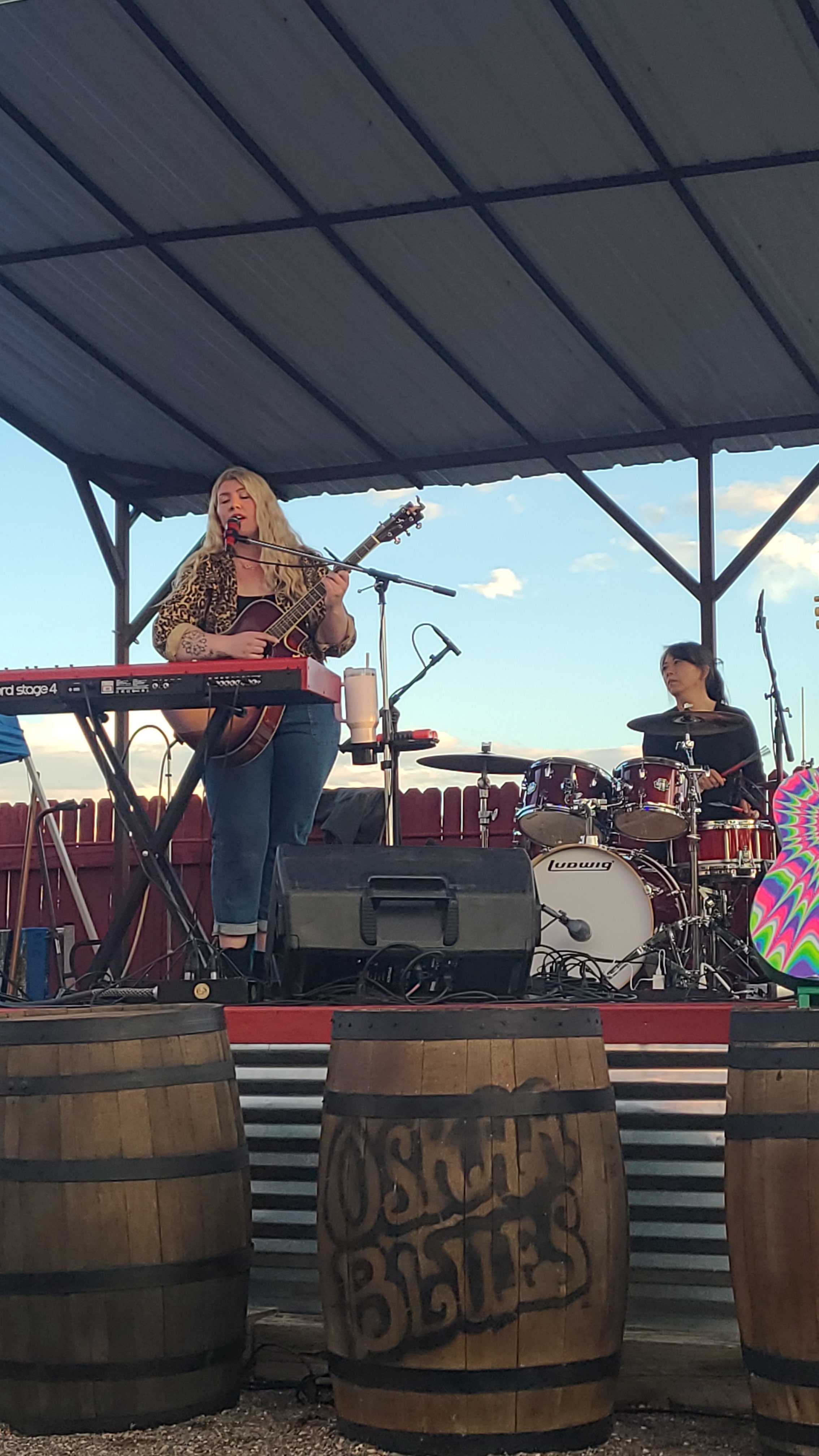 a group of people playing music on a stage in front of barrels