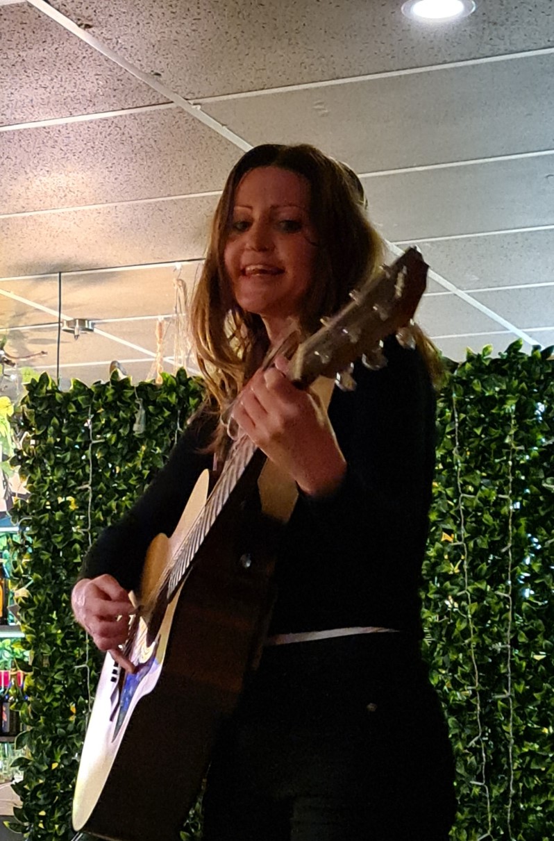 a woman playing an acoustic guitar in a store