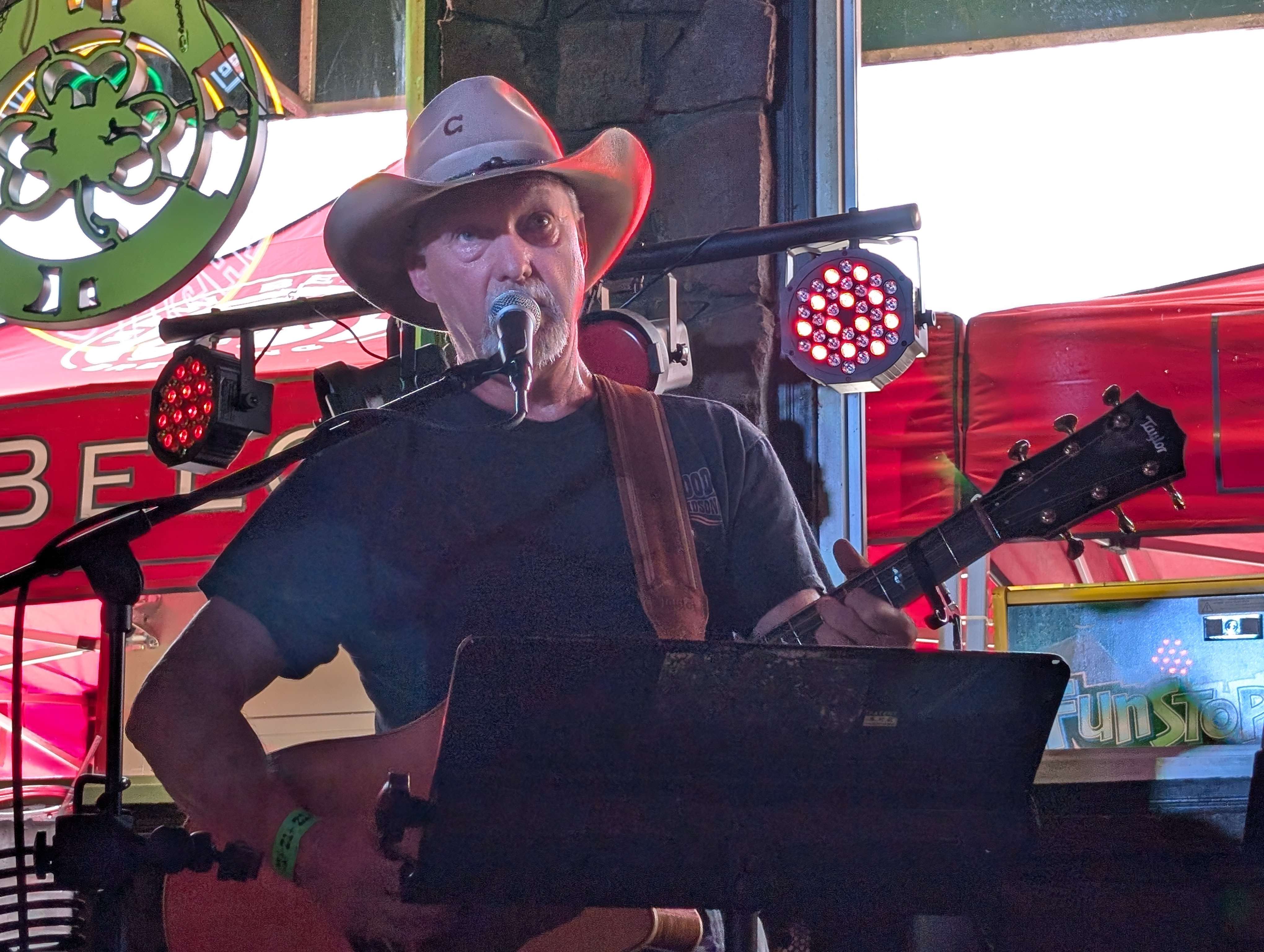 a man in a cowboy hat singing into a microphone