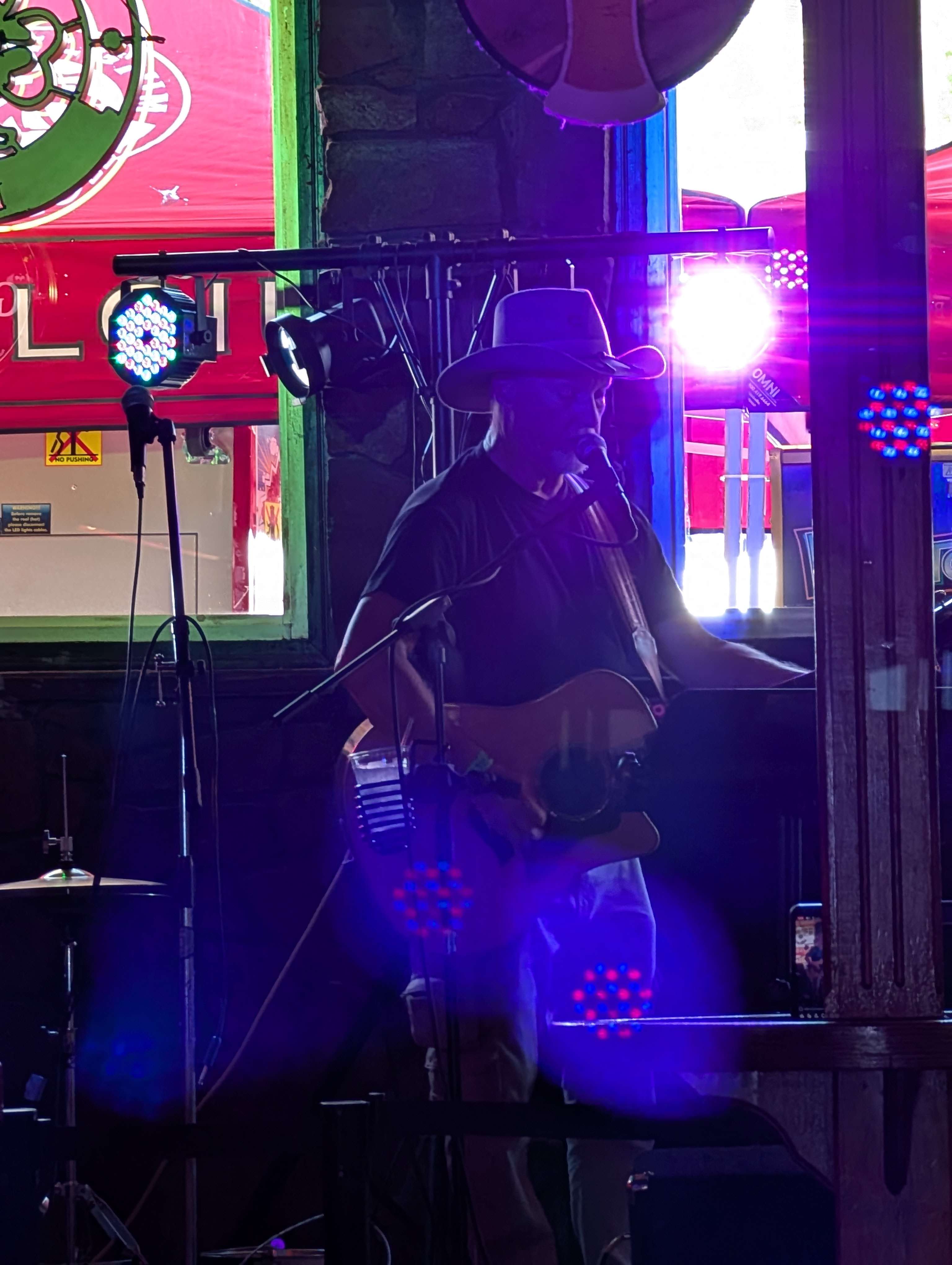 a man is playing a guitar at a bar