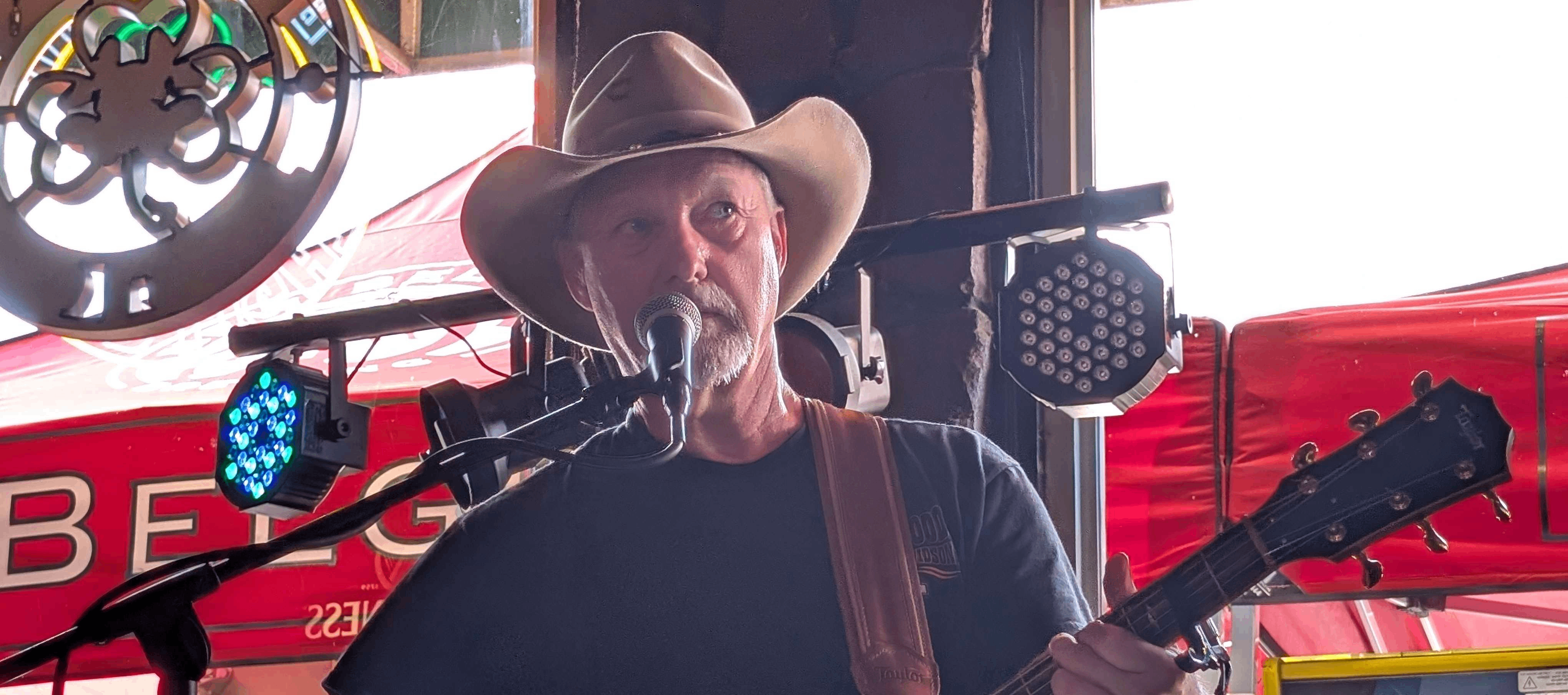 a man in a cowboy hat singing into a microphone