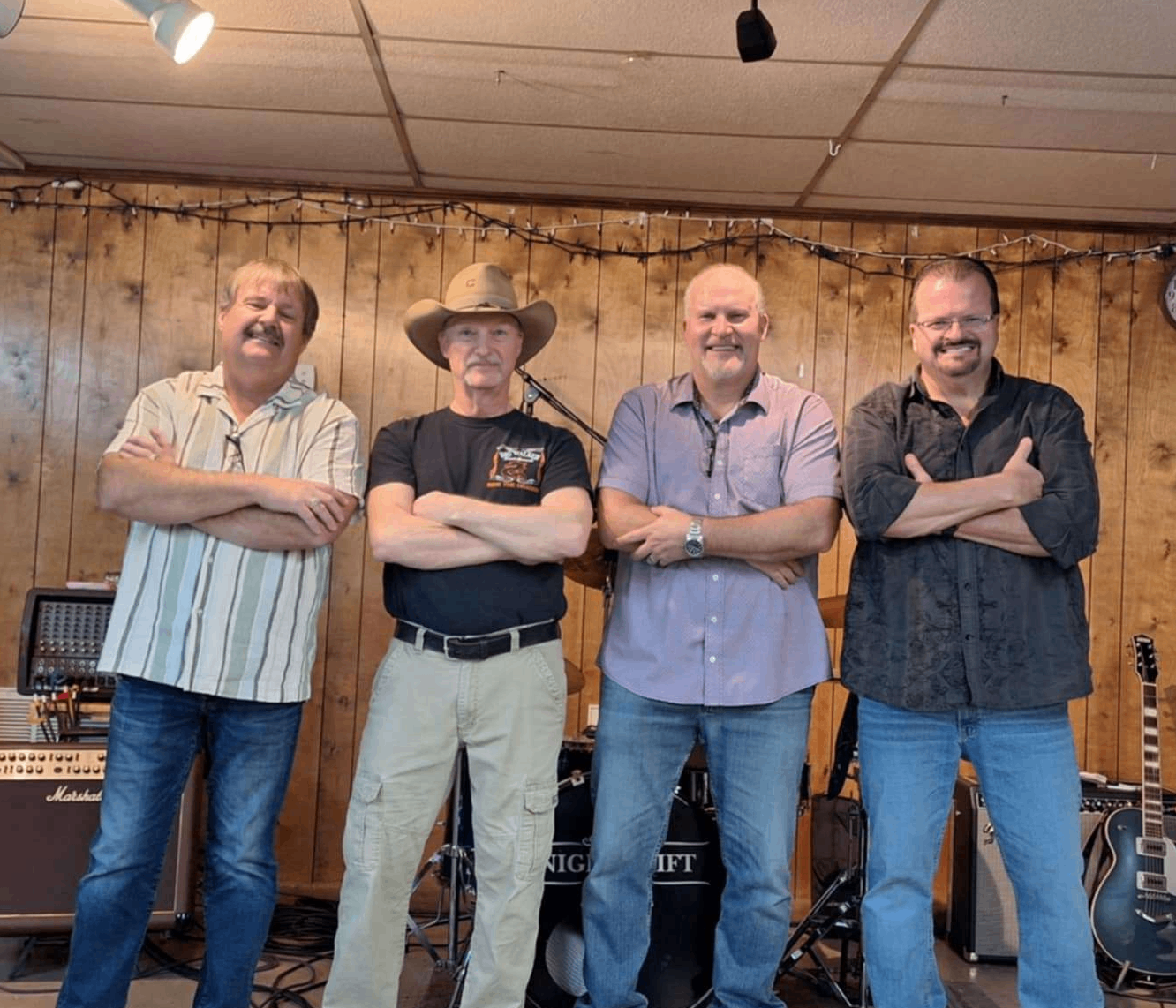 a group of men standing in a room with guitars