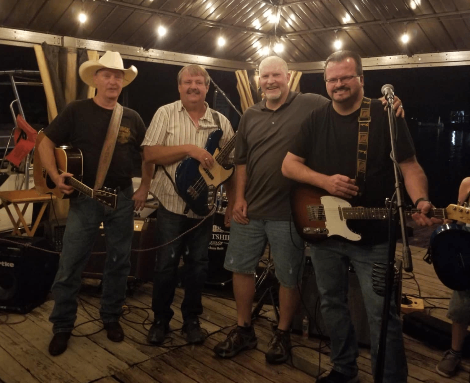 a group of men standing on a pier with guitars