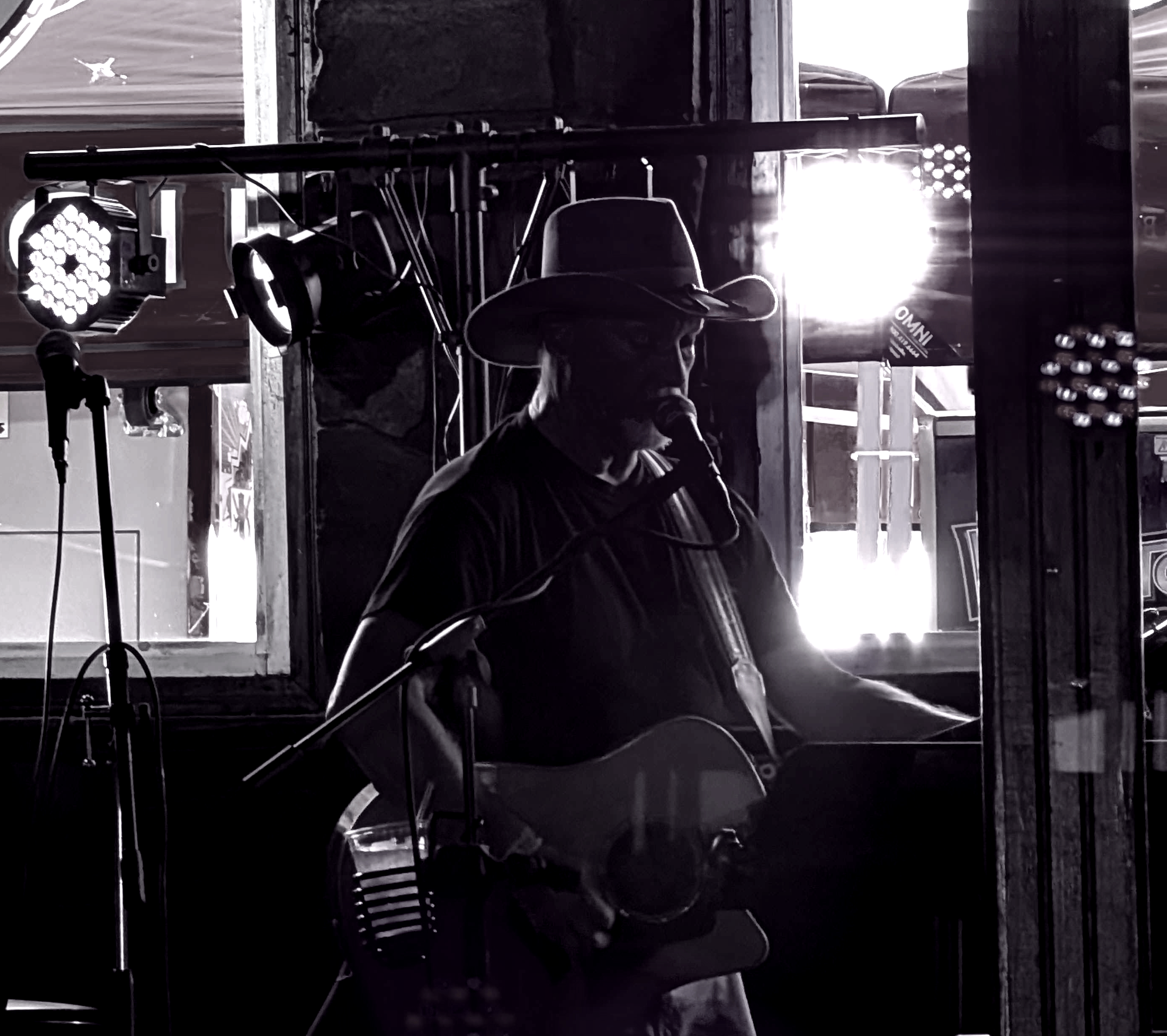a man in a cowboy hat playing a guitar